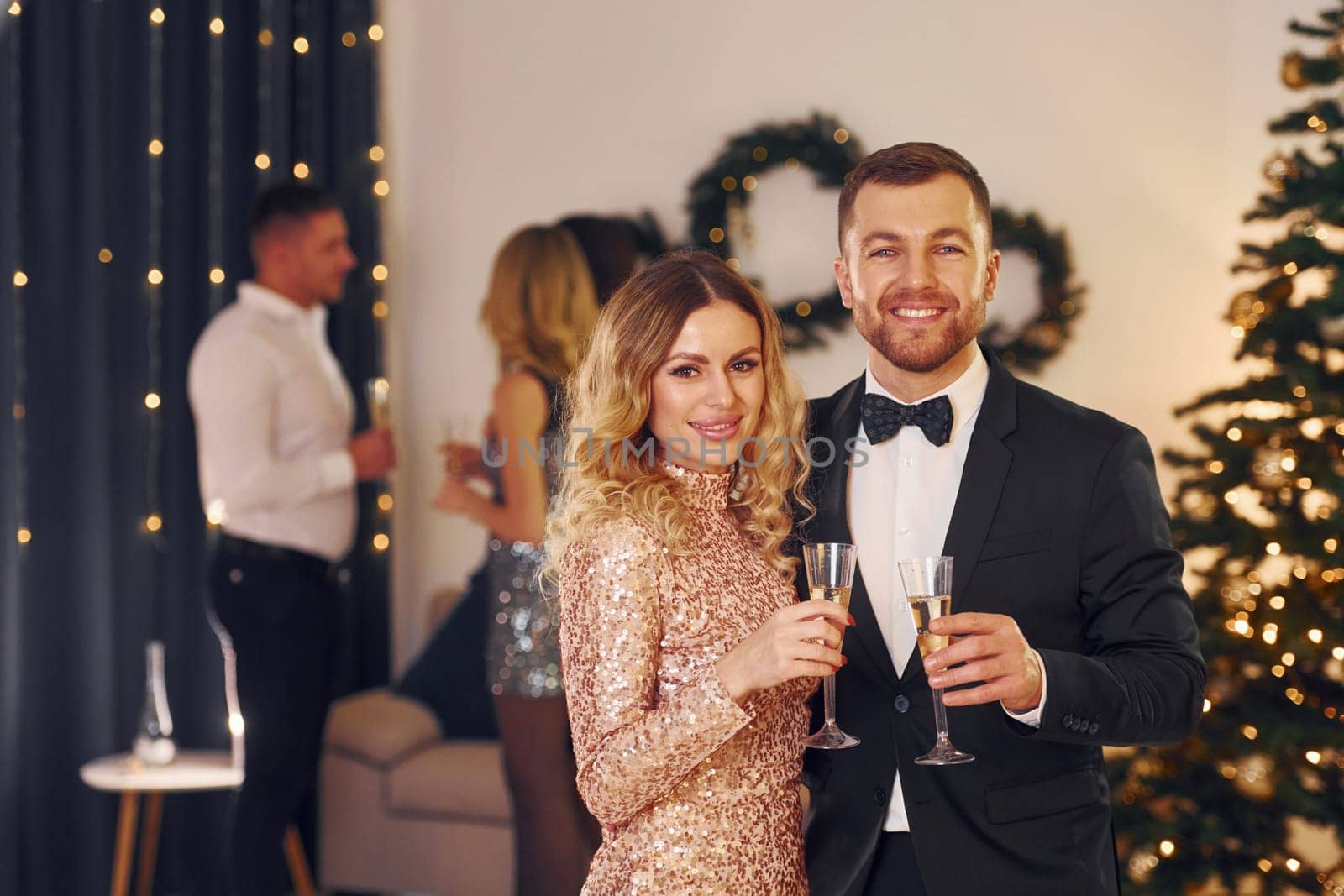 Young couple. Group of people have a new year party indoors together.