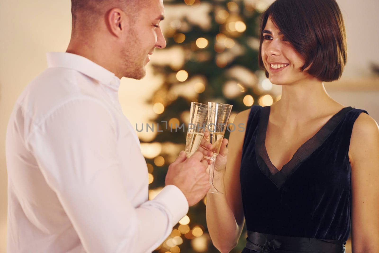 Happy couple have a new year party indoors together.