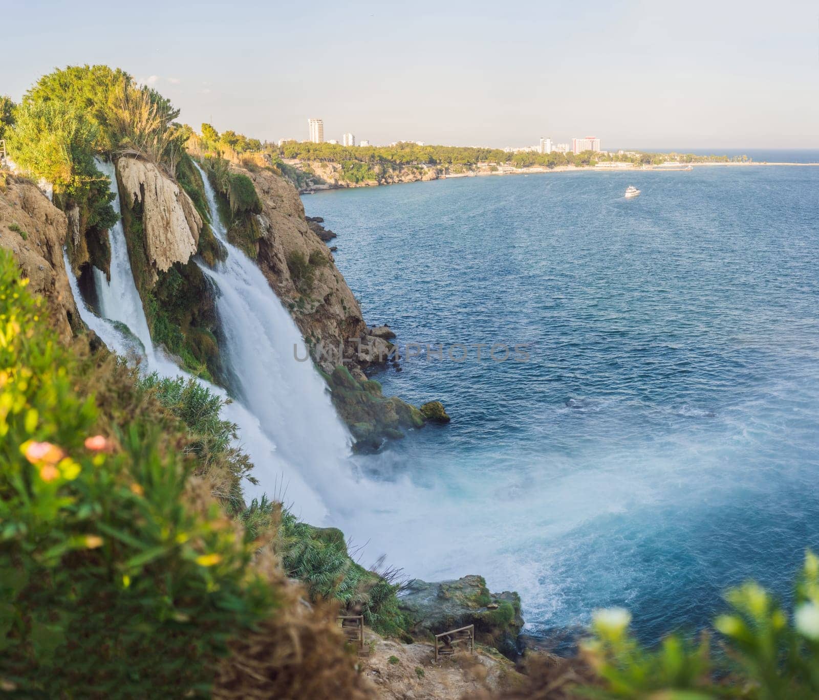 Lower Duden Falls drop off a rocky cliff falling from about 40 m into the Mediterranean Sea in amazing water clouds. Tourism and travel destination photo in Antalya, Turkey. Turkiye