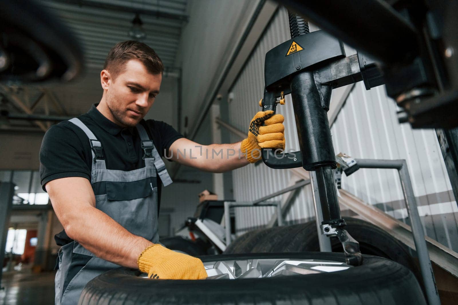 Strong hands. Man in uniform is working in the auto service.