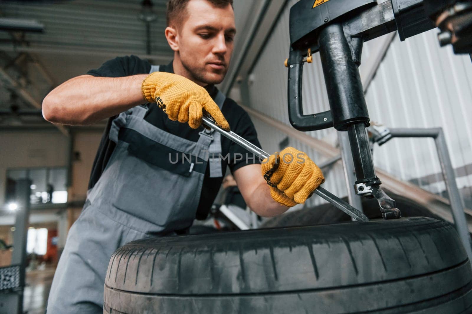 Employee at work. Man in uniform is in the auto service.