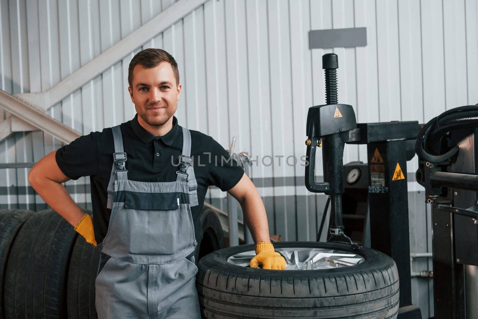 Employee at work. Man in uniform is in the auto service.