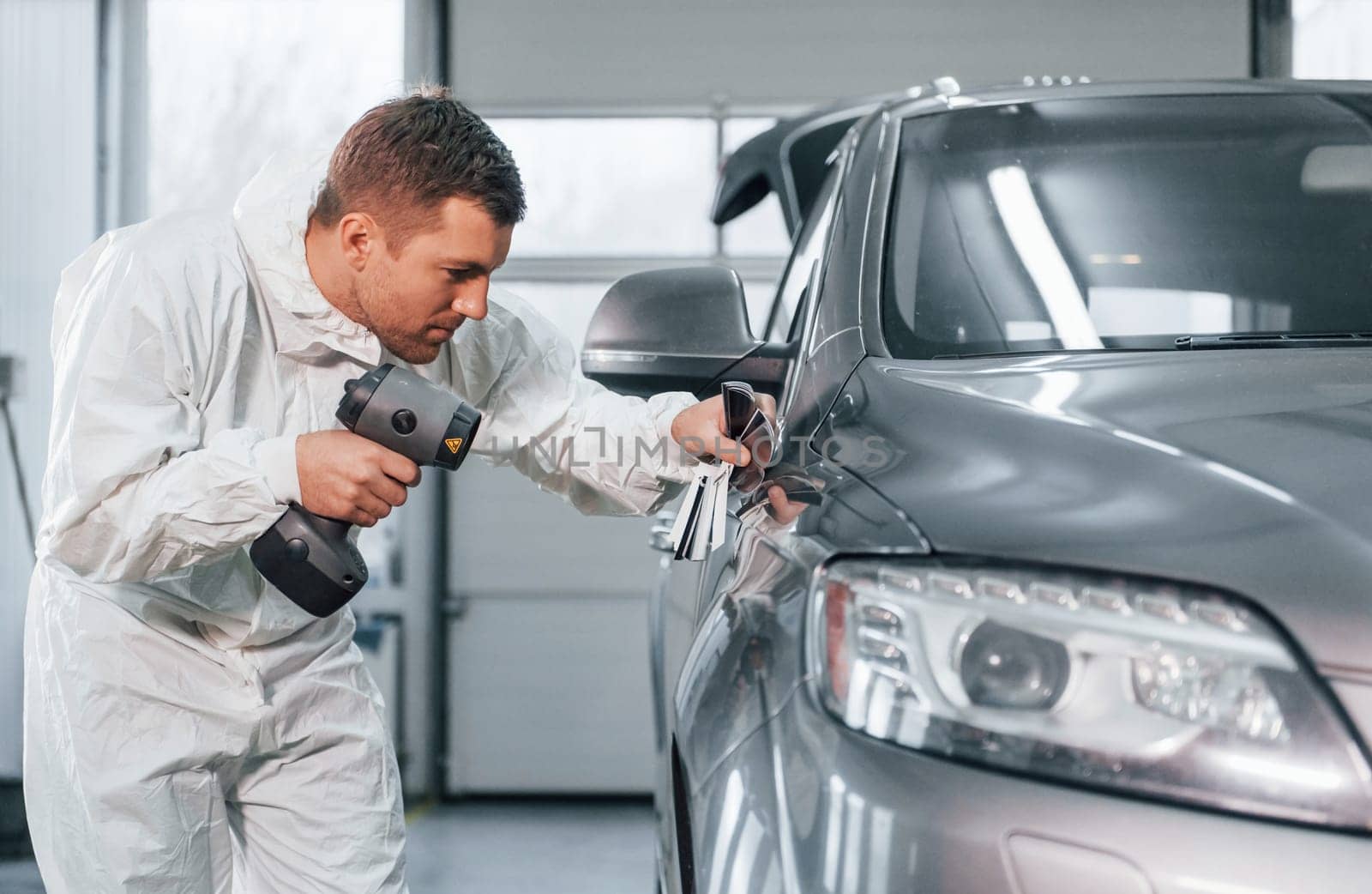 Professional worker. Man in uniform is in the auto service.