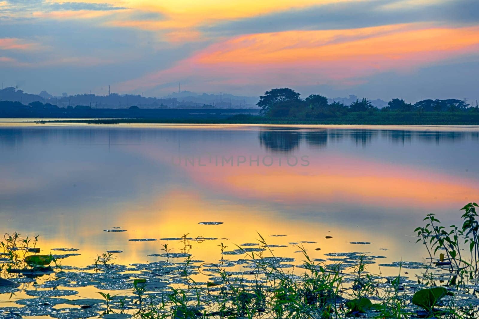 Beautiful view of Waduk Bunder or Water Dam Bunder in Gresik, East Java, Indonesia during sunrise and cloudy wheater.