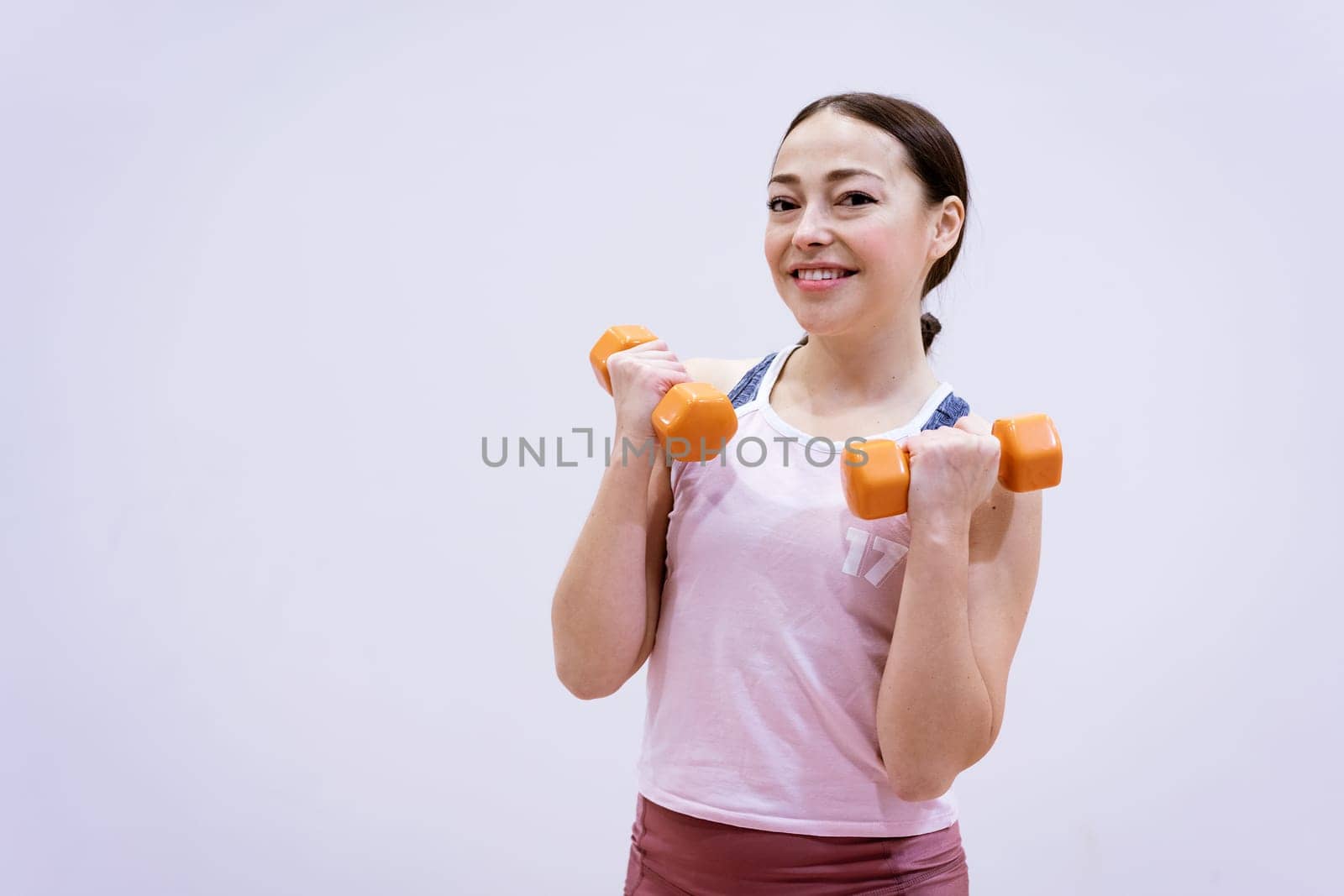 happy caucasian woman in sportswear is engaged with dumbbells. Healthy lifestyle concept