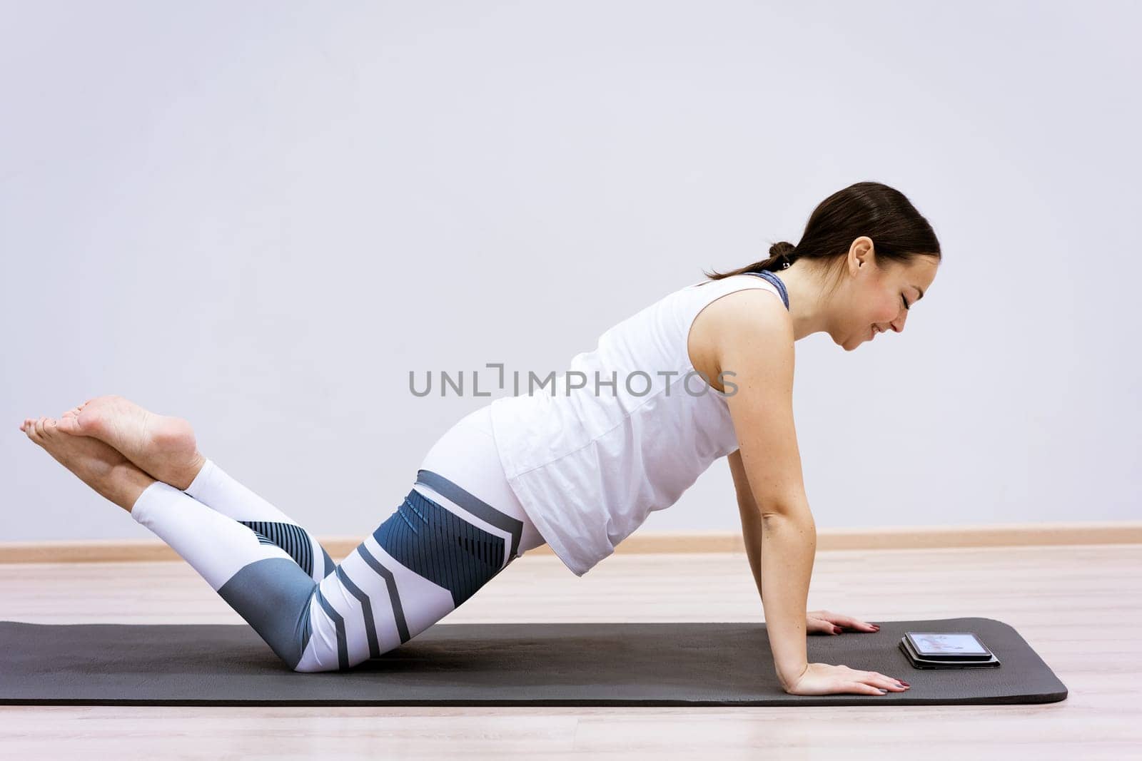 A woman goes in for sports watching an online video from a tablet. Fitness class concept ss workout without leaving home