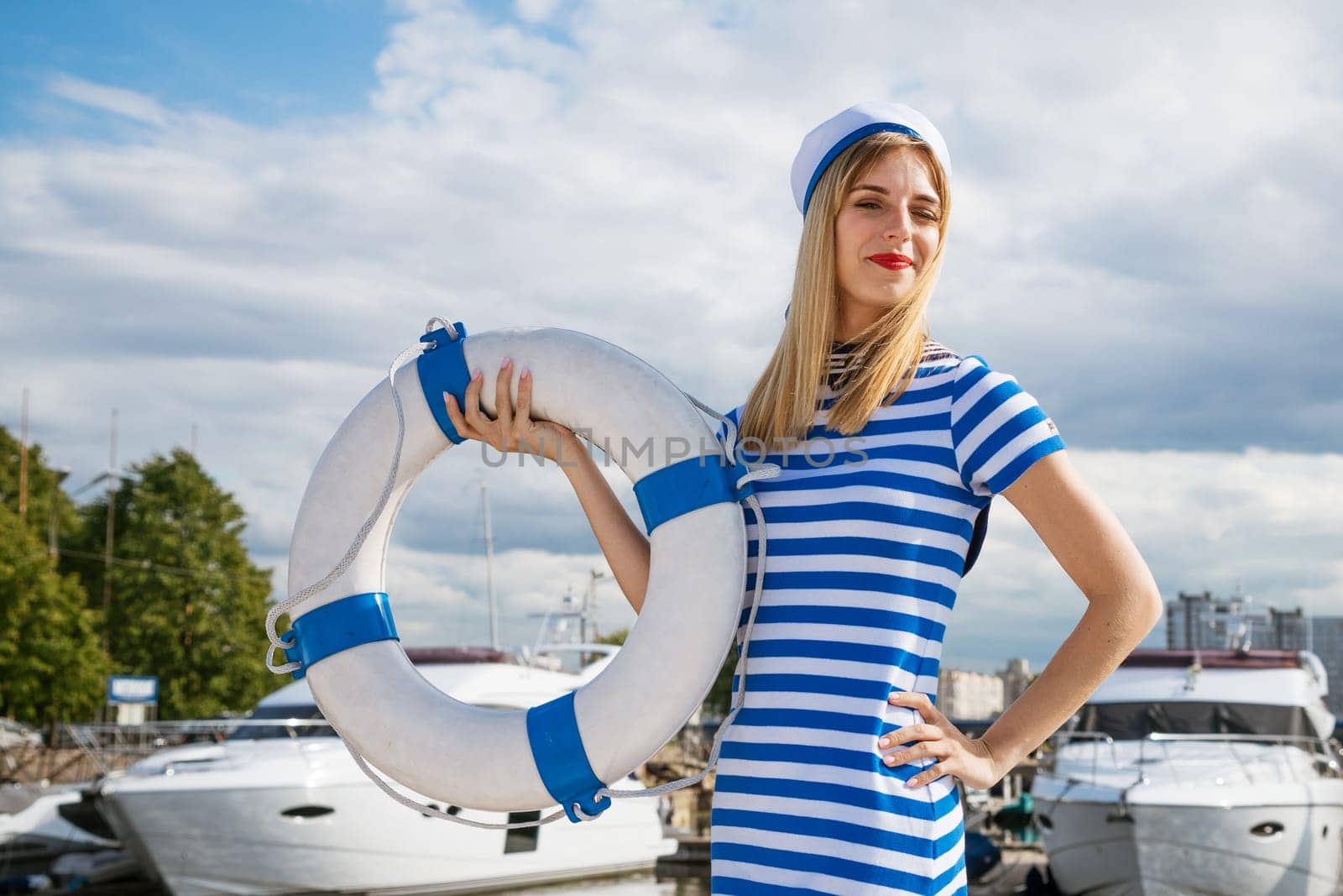 Young woman standing on yacht posing with lifebuoy by EkaterinaPereslavtseva