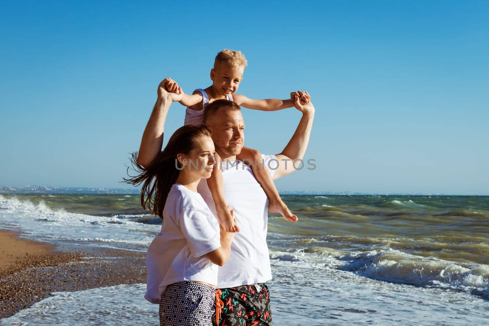 joyful family on the beach People having fun view summertime vacation. Father mother and child against blue sea and sky background. vacation travel concept