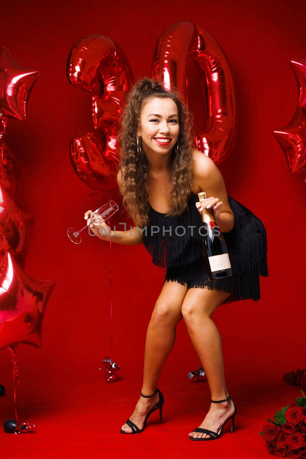 Beautiful woman posing on a red background with balloons by EkaterinaPereslavtseva