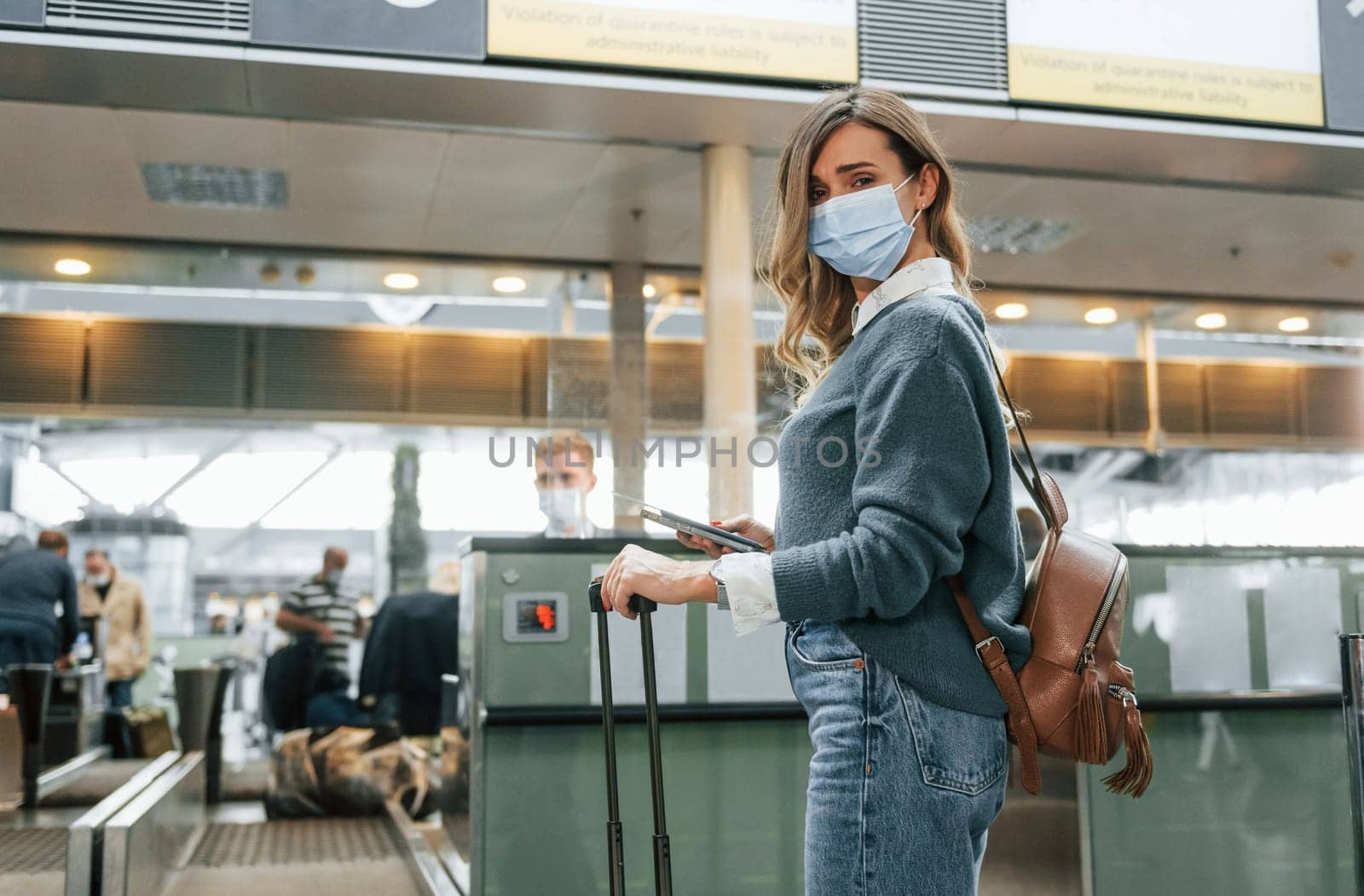 Receiving help from worker. Young female tourist is in the airport at daytime.