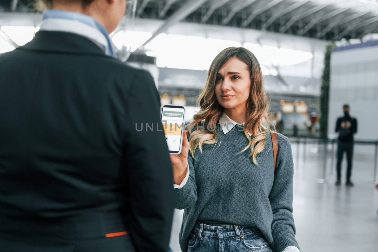 With documents. Young female tourist is in the airport at daytime by Standret