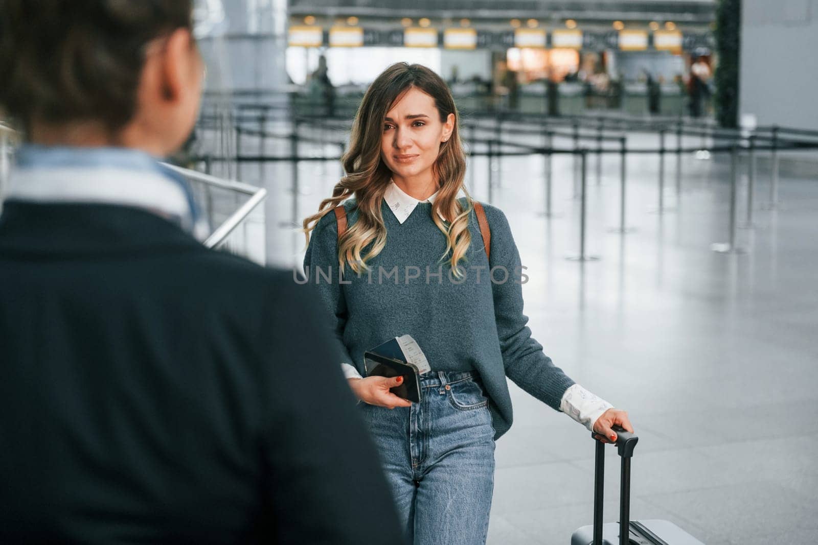 Pass procedure. Young female tourist is in the airport at daytime.