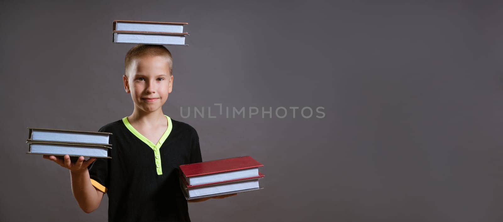 little boy hold the stacks of books in your hands and on your head by EkaterinaPereslavtseva