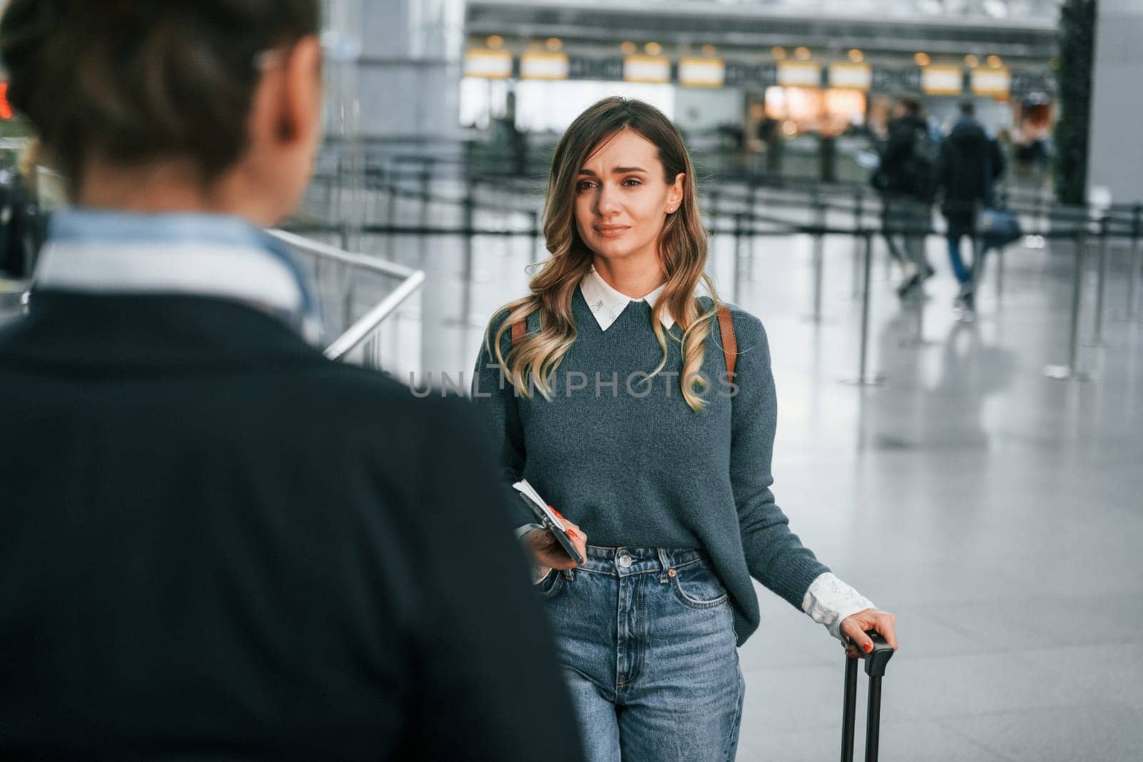 Pass procedure. Young female tourist is in the airport at daytime.