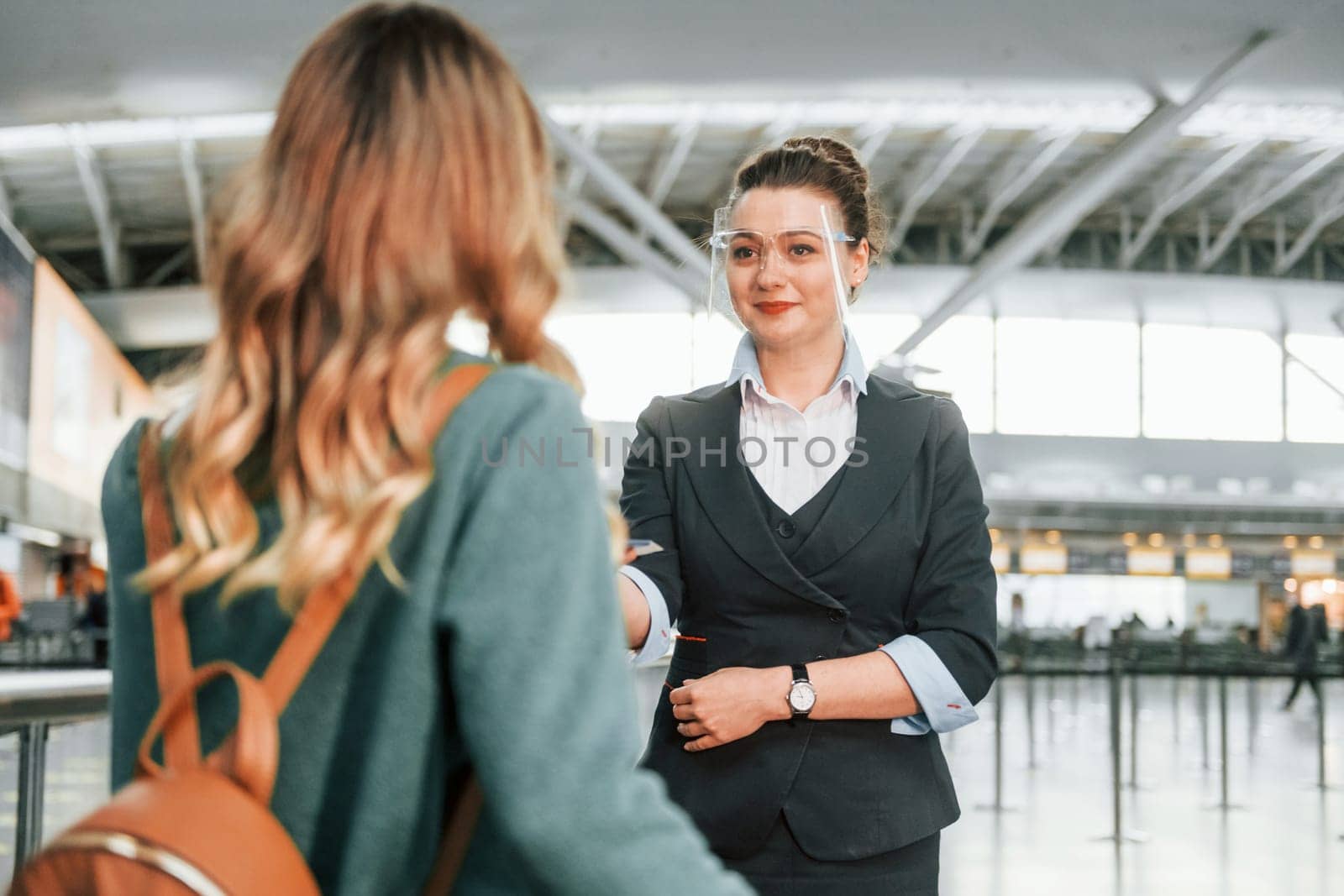 Pass procedure. Young female tourist is in the airport at daytime.