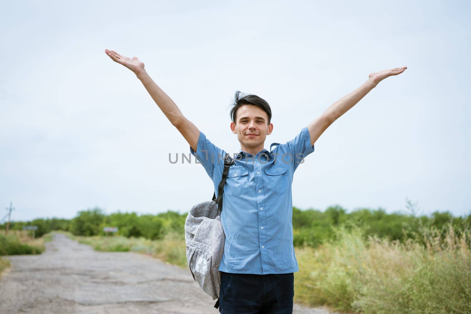 Happy young man posing with raised arms, standing by EkaterinaPereslavtseva