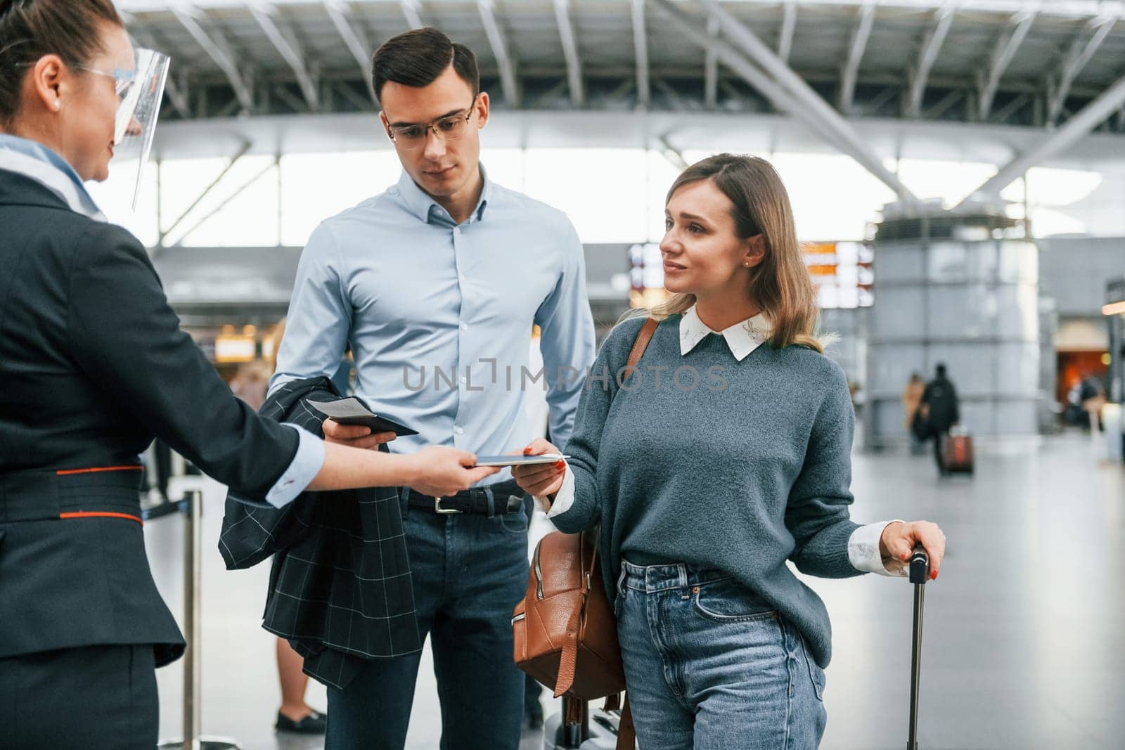 Checking documents at the entrance. Young couple is in the airport together.