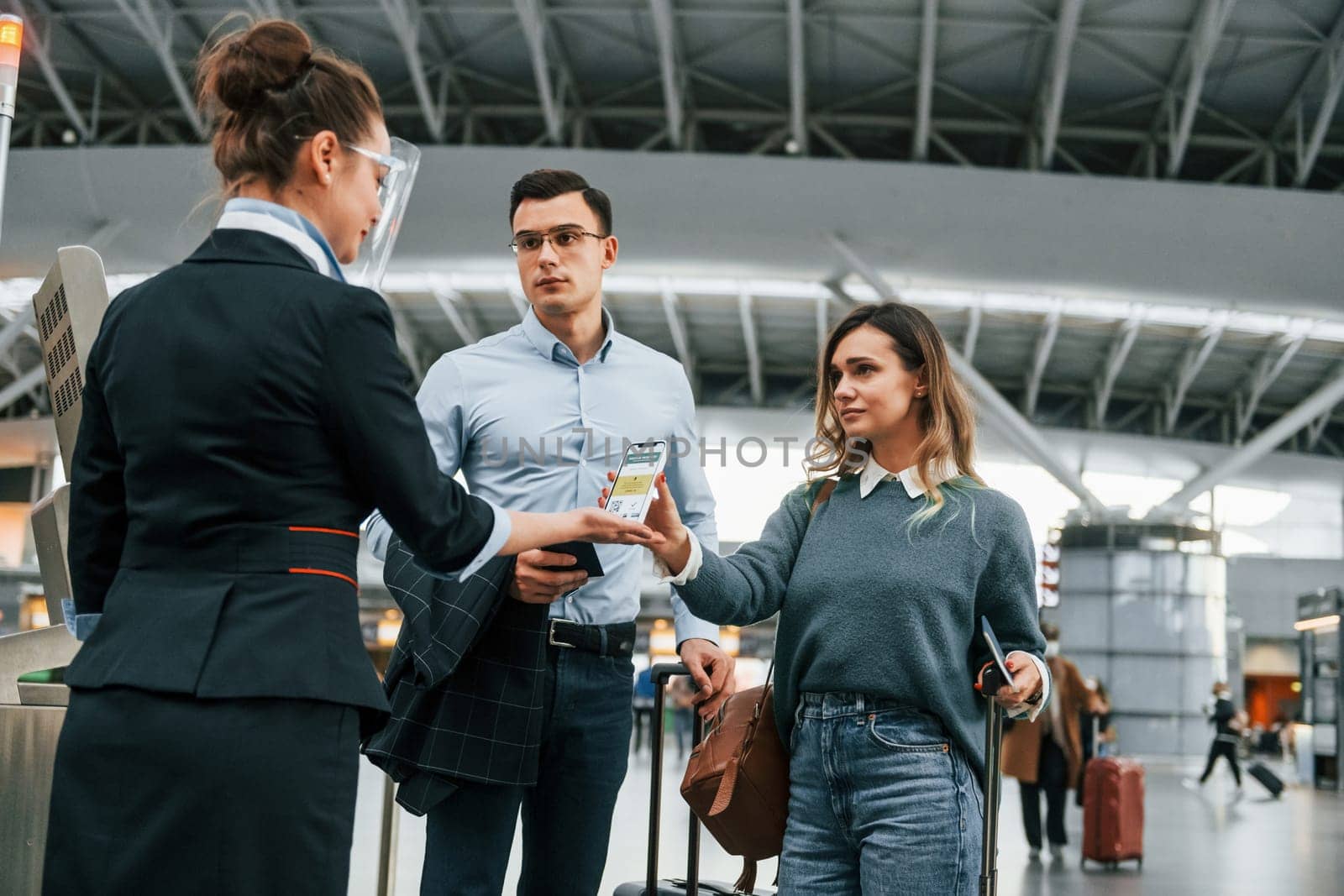 Checking documents at the entrance. Young couple is in the airport together.