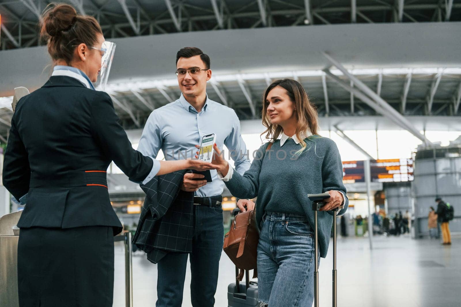 Showing vaccination certificate. Young couple is in the airport together.