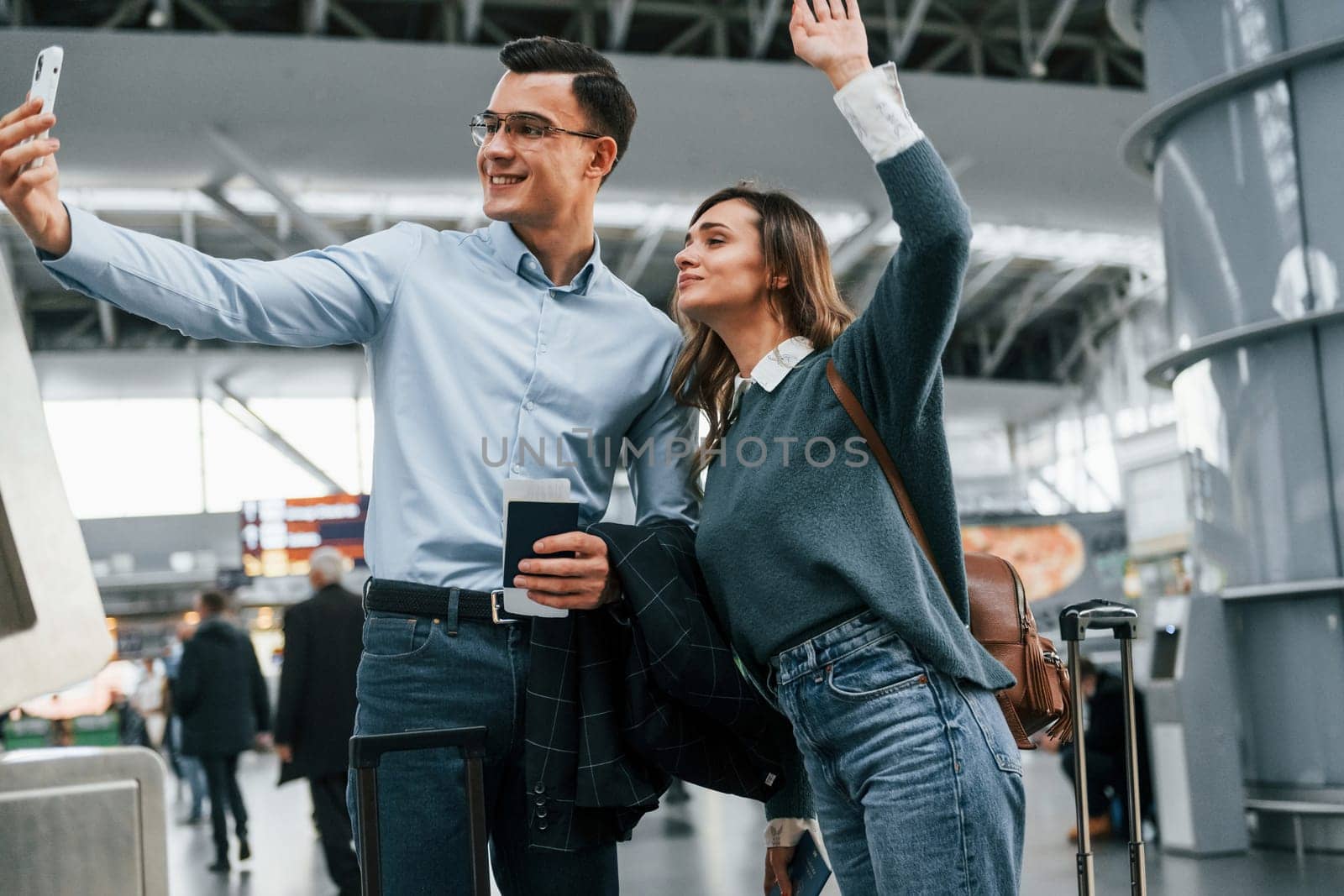 Making selfie. Young couple is in the airport together.