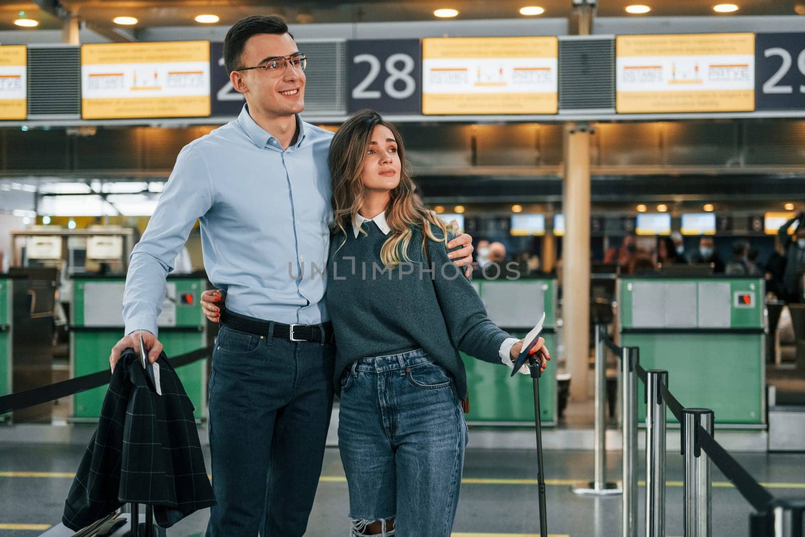 Embracing each other. Young couple is in the airport together.