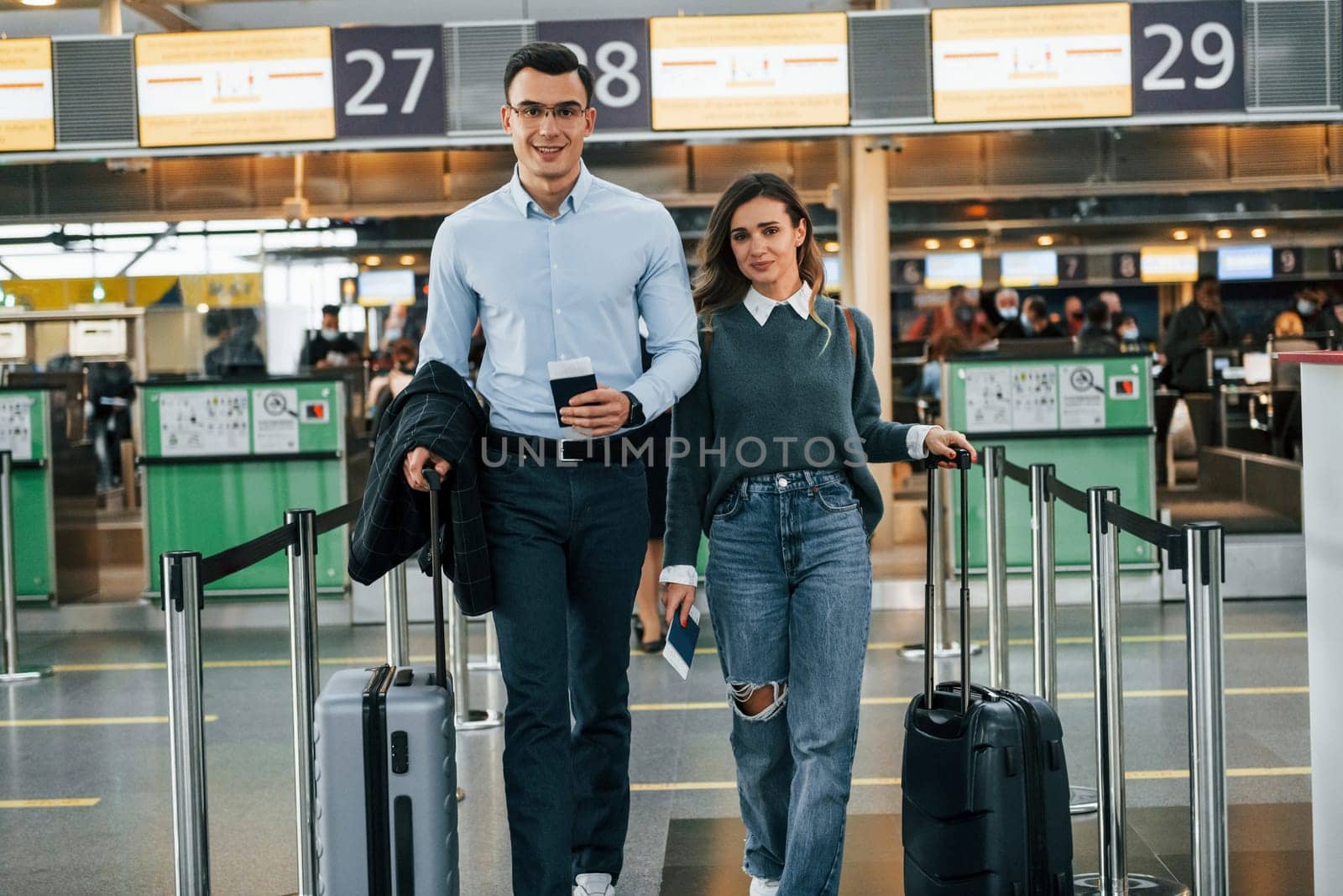 Walking forward. Young couple is in the airport together.