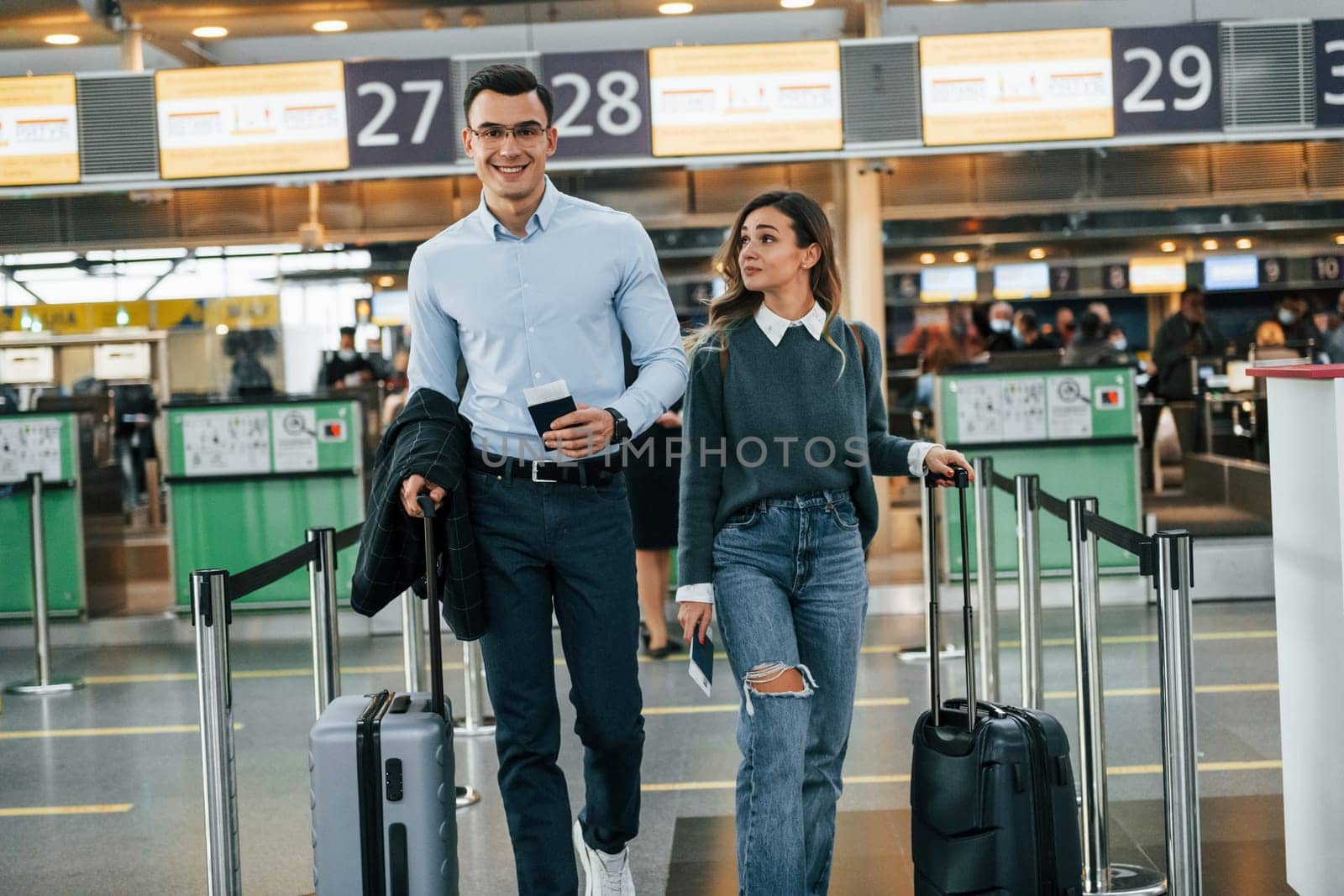 Walking forward. Young couple is in the airport together.