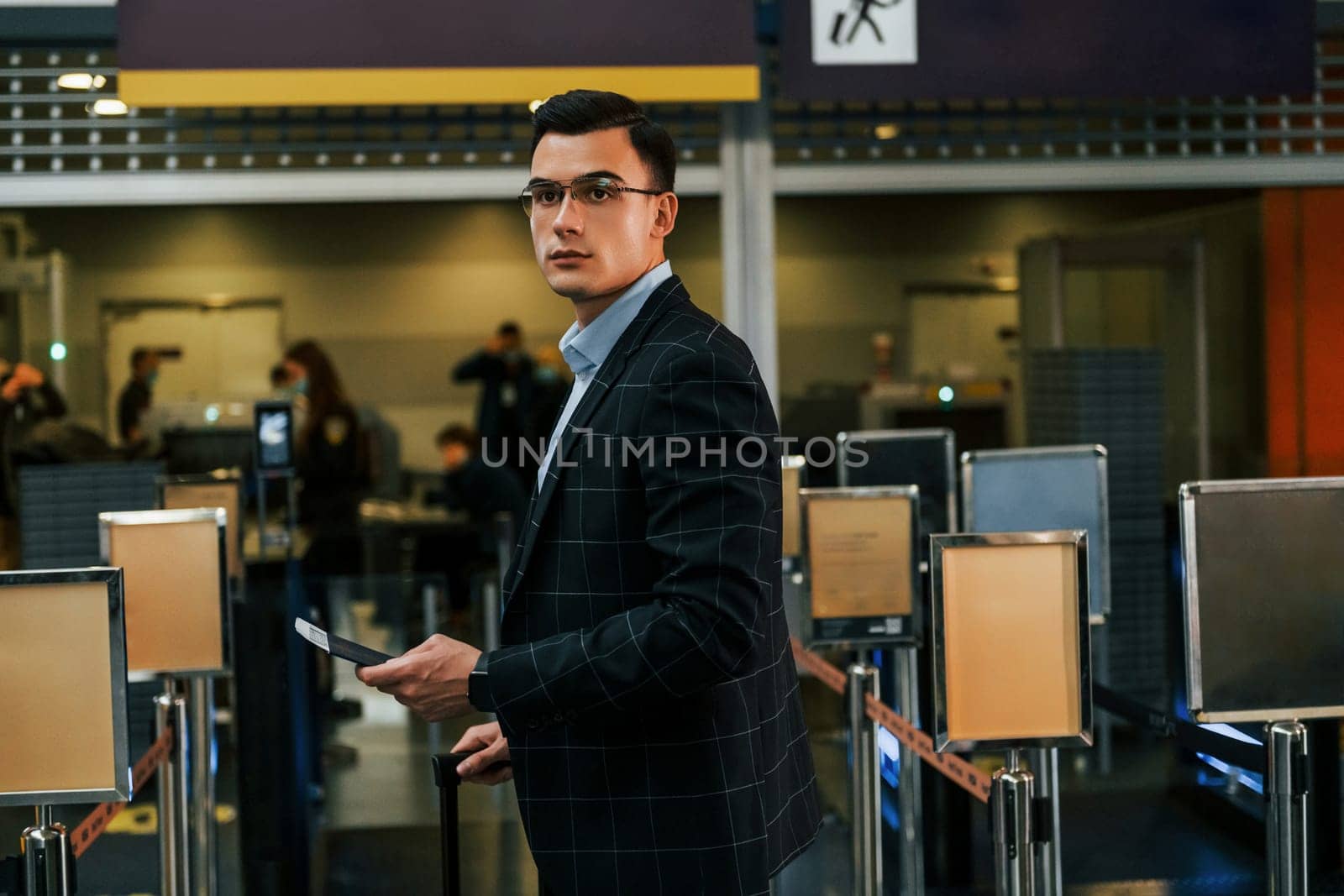 Modern background. Young businessman in formal clothes is in the airport at daytime by Standret