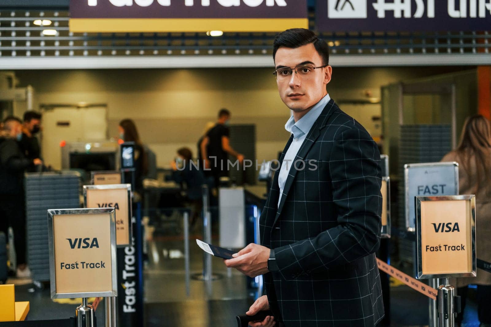 Modern background. Young businessman in formal clothes is in the airport at daytime.