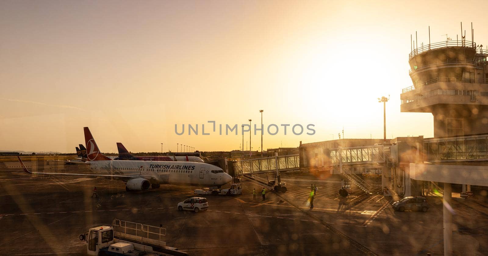 Airplanes of Turkish airlines and Wizz air docked in the airport runway by bepsimage