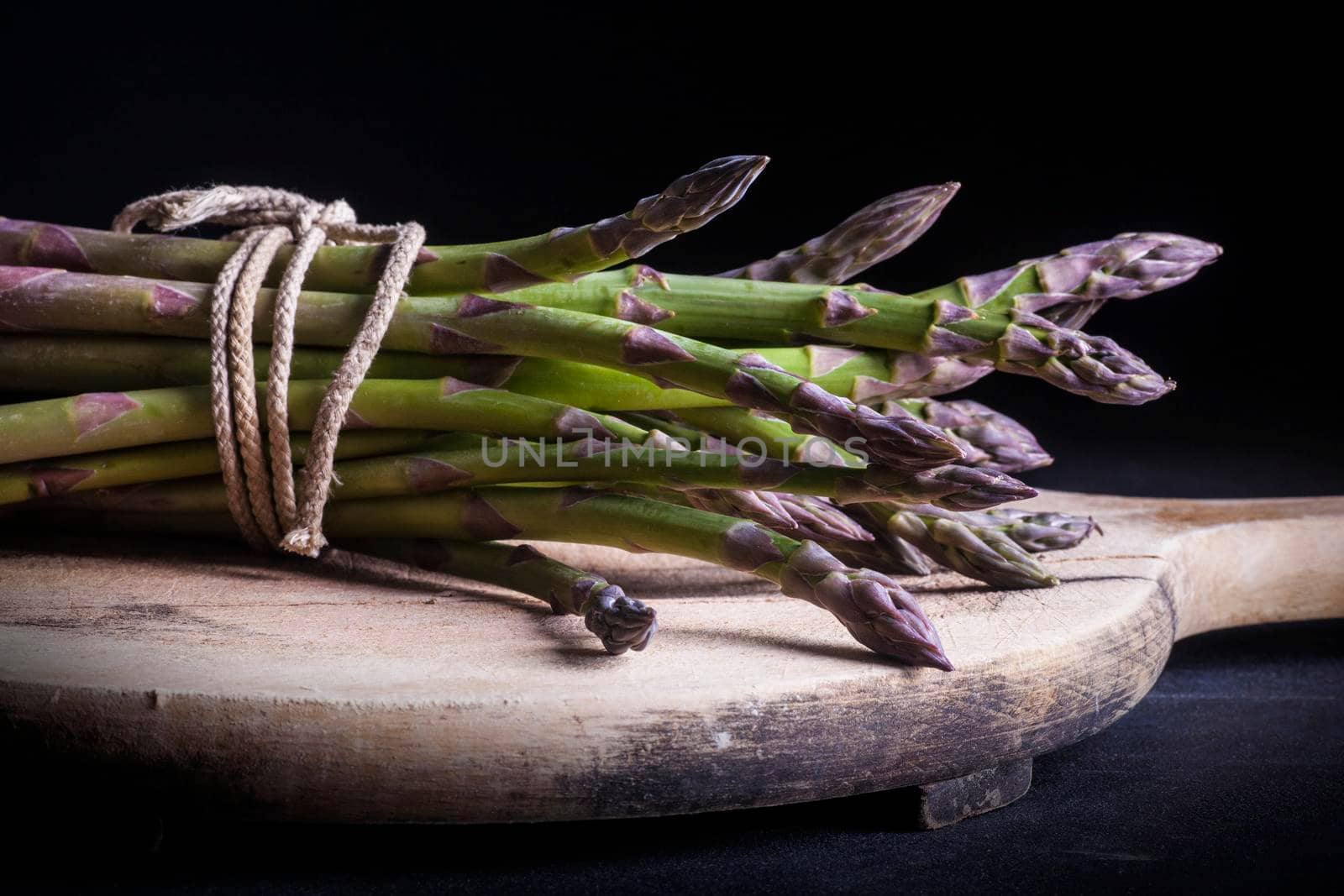 Close up of bunch of fresh asparagus by bepsimage