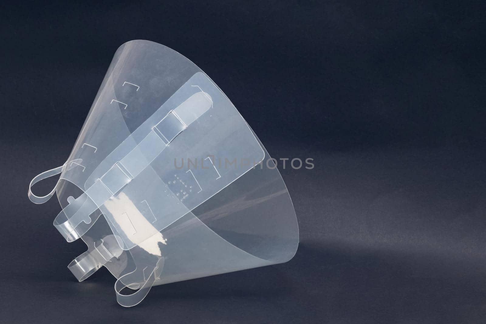 Plastic protective collar for an animal close up on gray background, copy space
