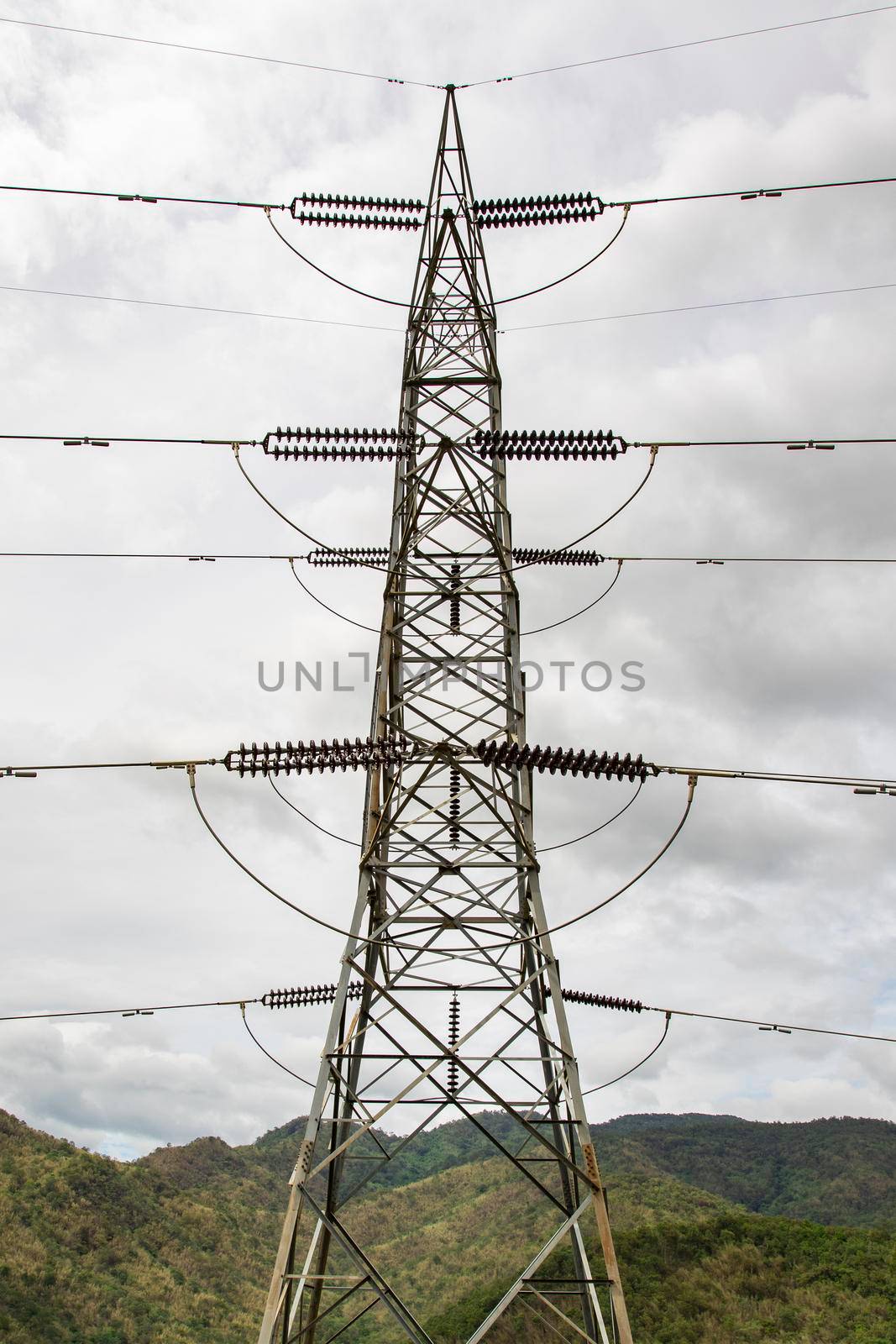 Image of high voltage electricity pylon and transmission power line with sky and mountain background. by yod67