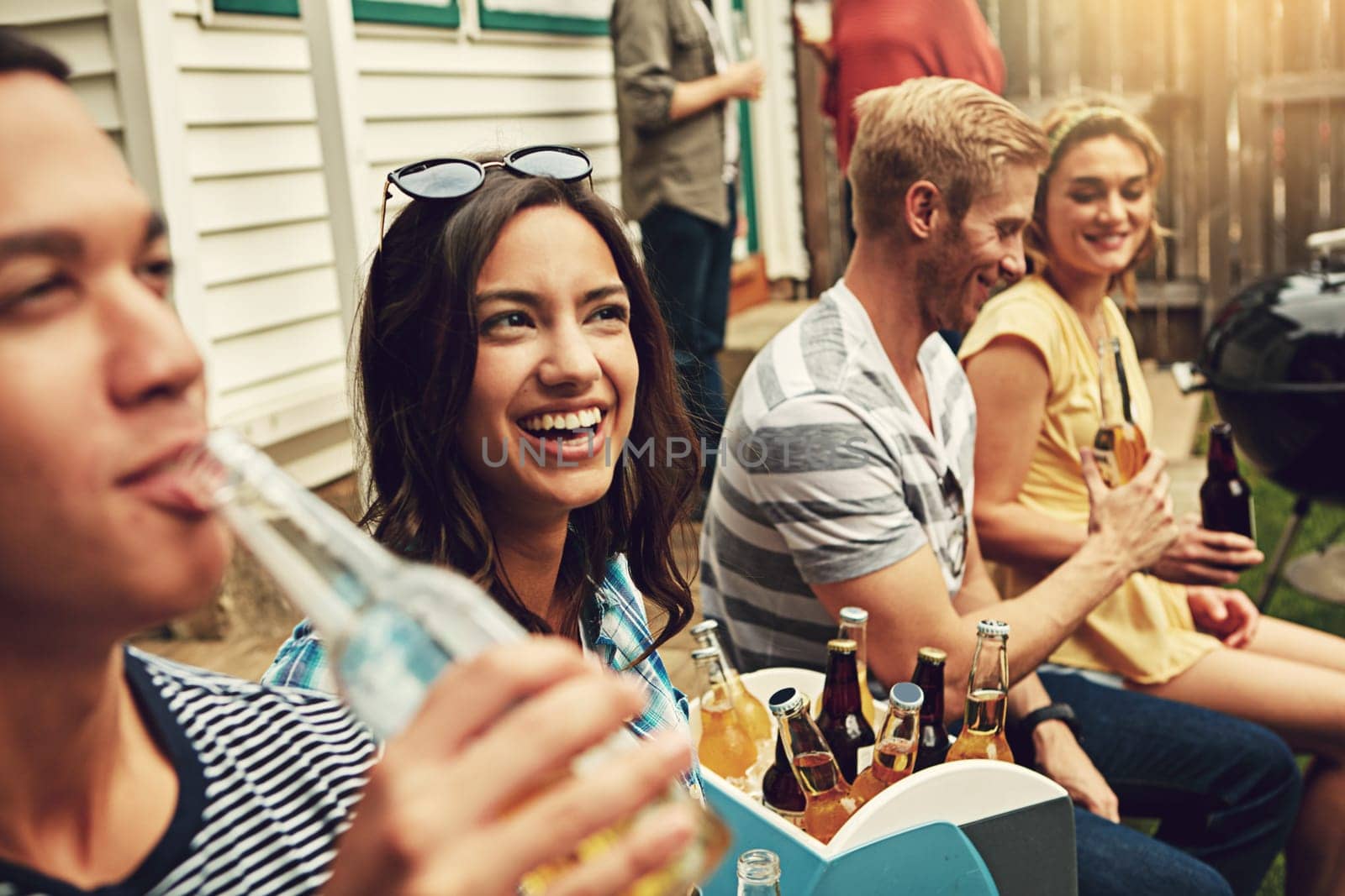 Their weekend is going down well. a group of friends enjoying a party outdoors. by YuriArcurs