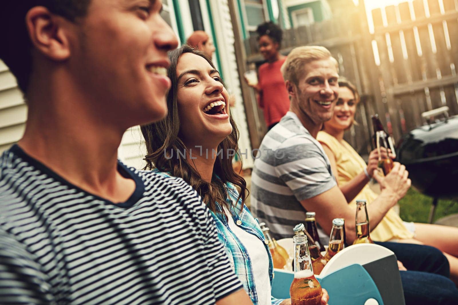 Just chill out. a group of friends enjoying a party outdoors. by YuriArcurs