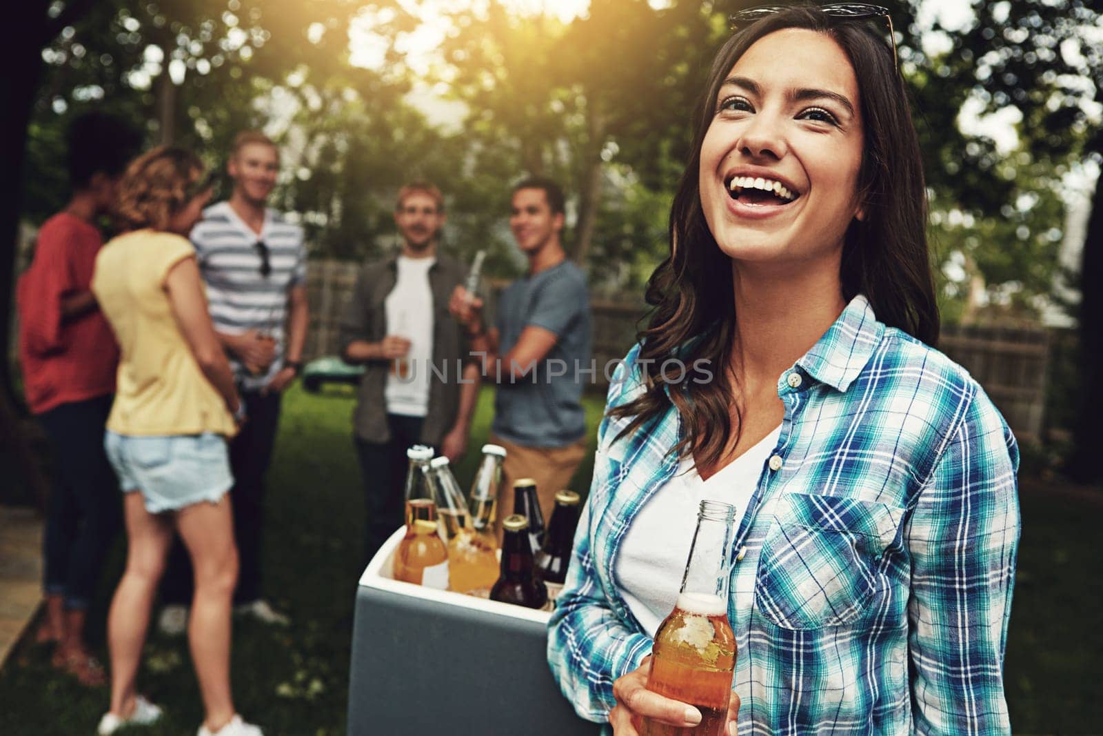 Bring on the bliss. a young woman enjoying a party with friends outdoors. by YuriArcurs