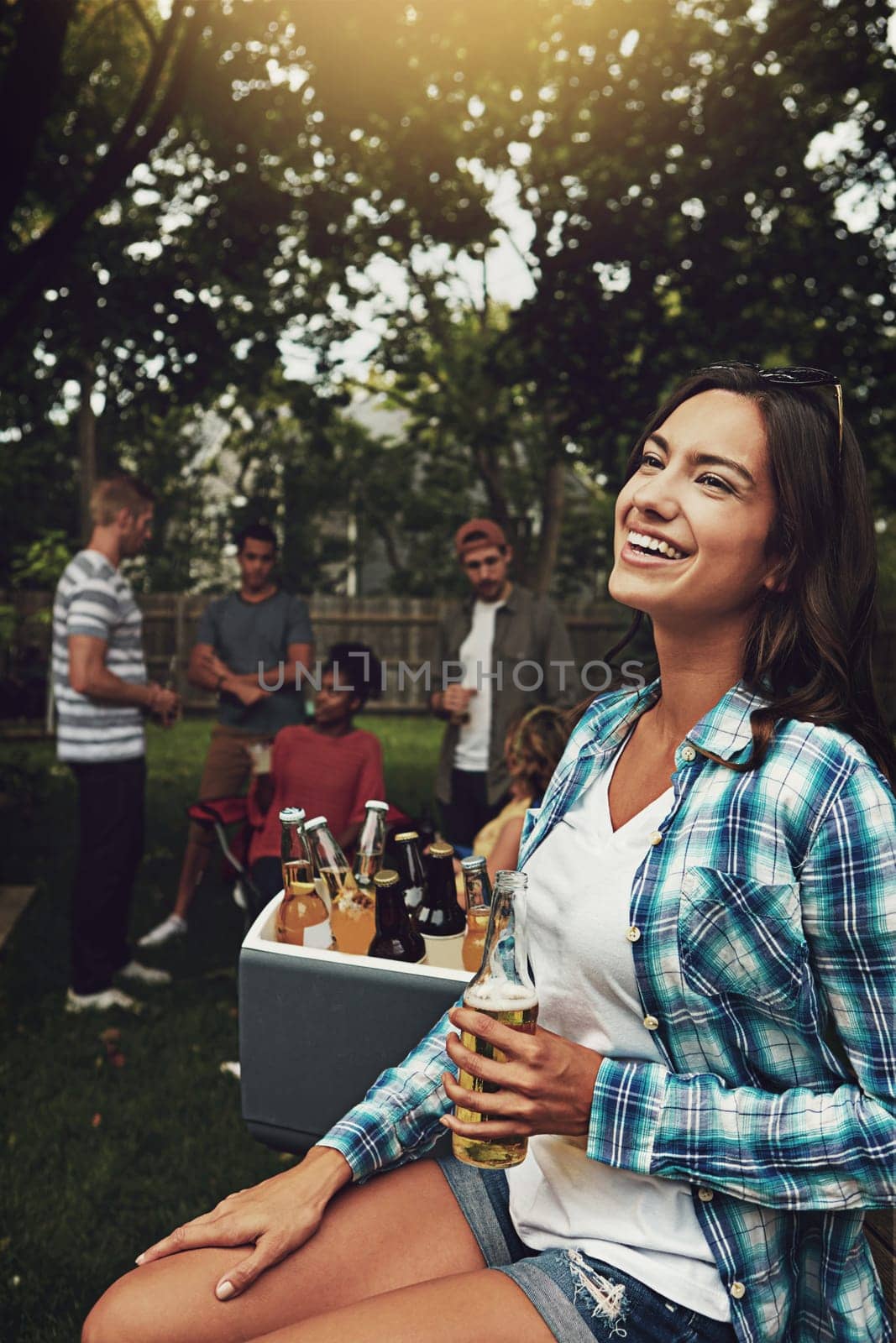 Shes really enjoying herself. a young woman enjoying a party with friends outdoors. by YuriArcurs