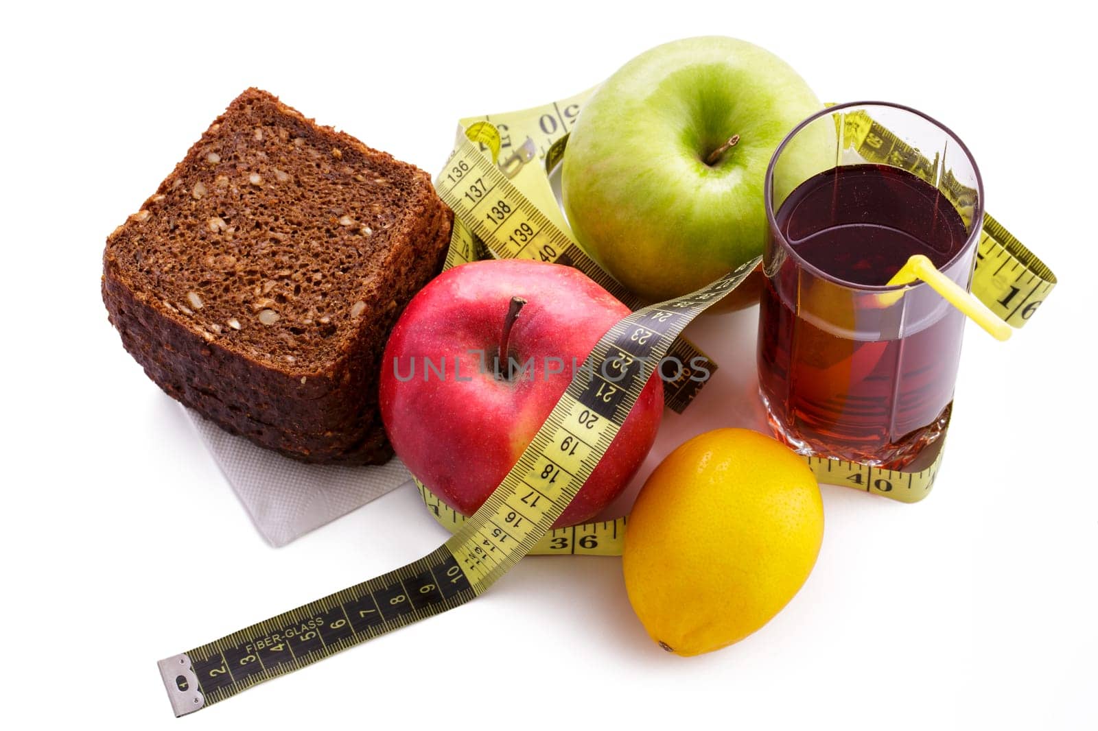 Rye bread with green and red apples and juice in a glass on a white plate with a yellow measuring tape. Diet and healthy food concept