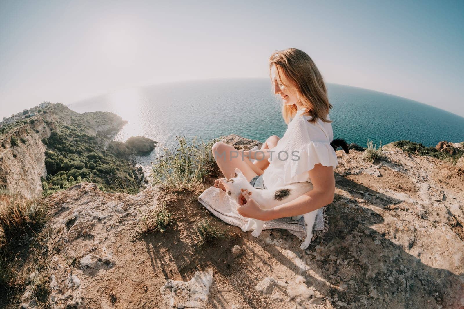 Woman sea laptop. Business woman petting cat and working on laptop by the sea. Close up on hands of pretty lady typing on computer outdoors summer day. Freelance, digital nomad and holidays concept. by panophotograph