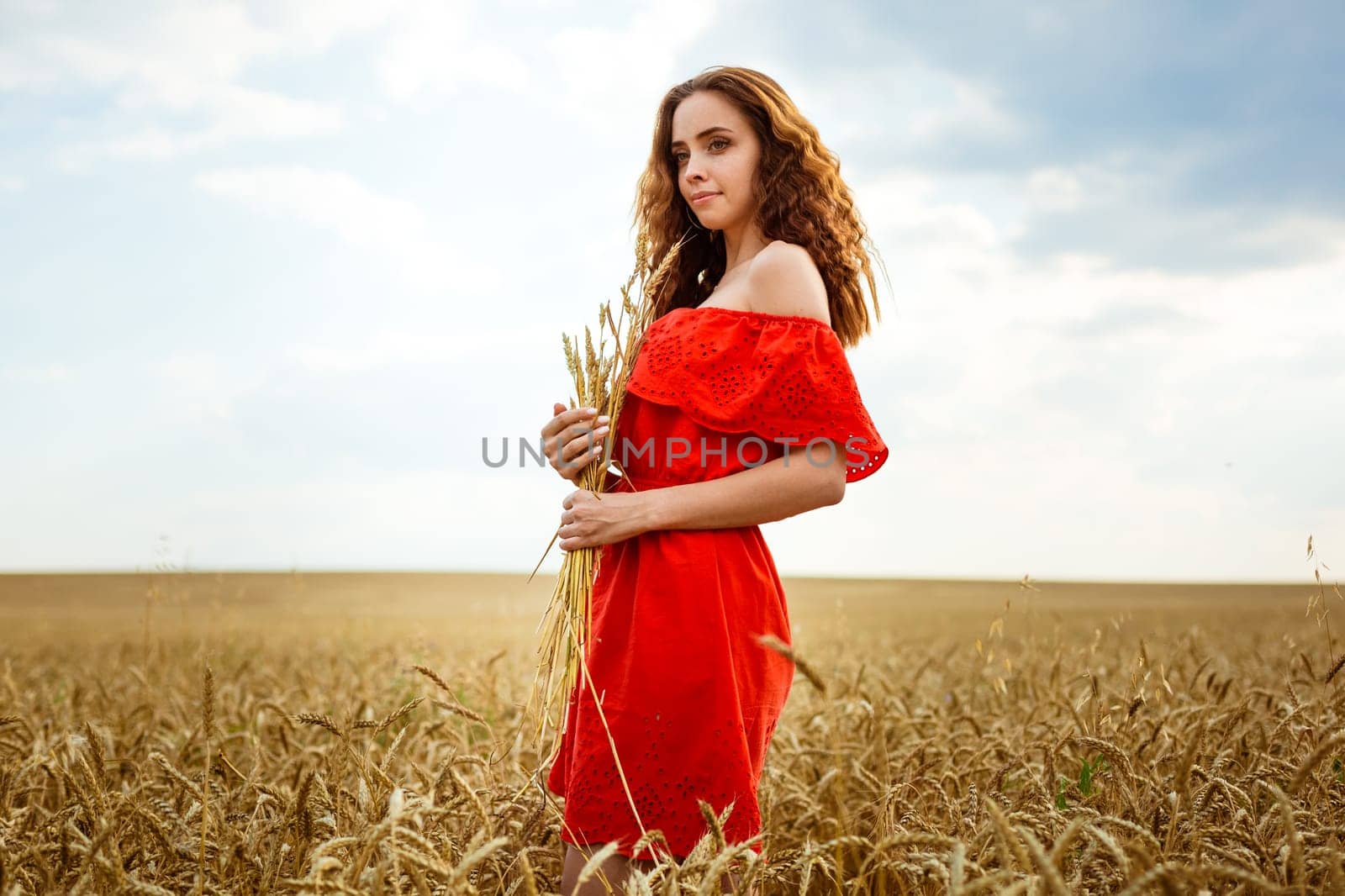 Young beautiful woman in golden wheat field. Happy woman by EkaterinaPereslavtseva