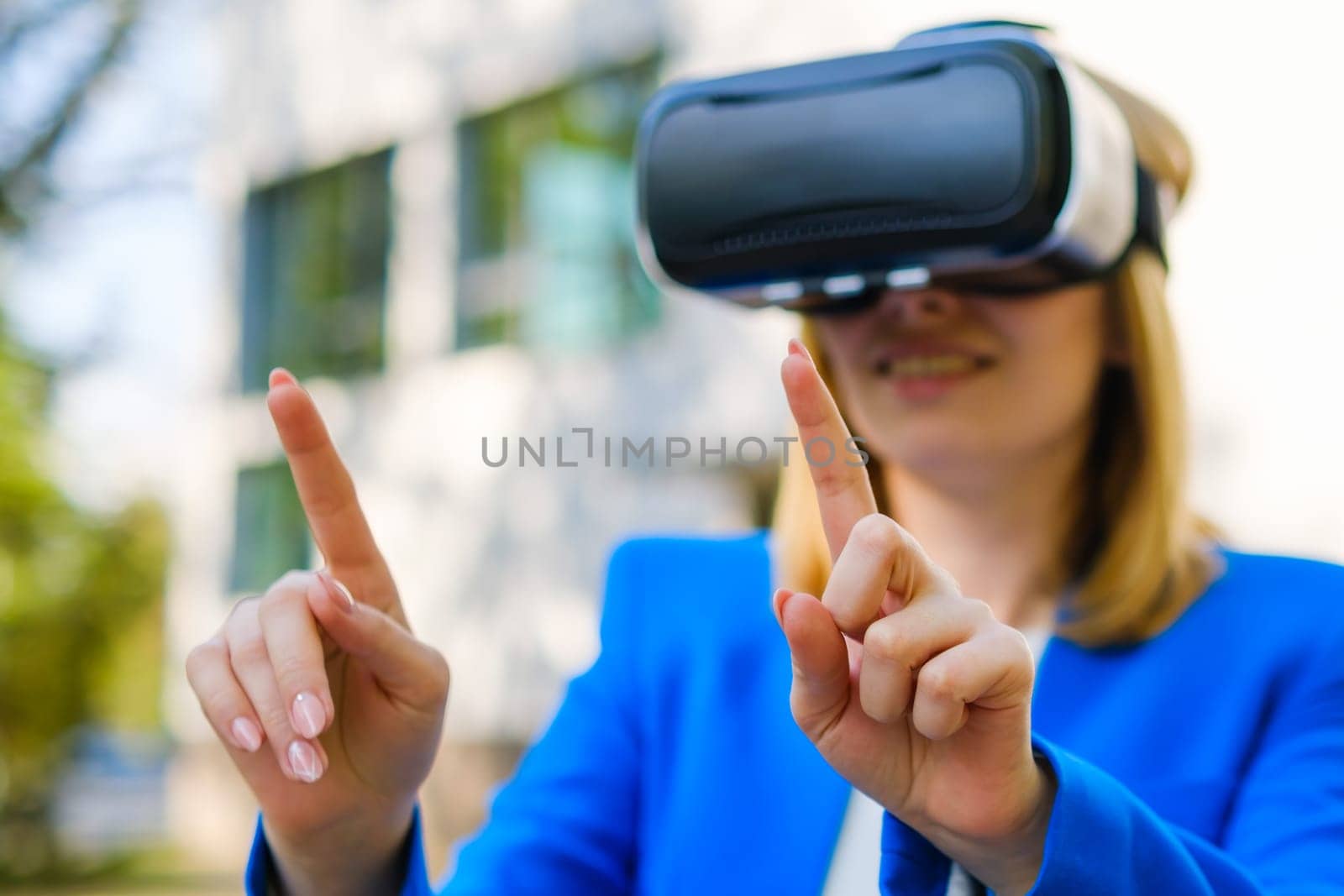 Business woman using VR goggles, moving her head touching the simulation screen in the park.