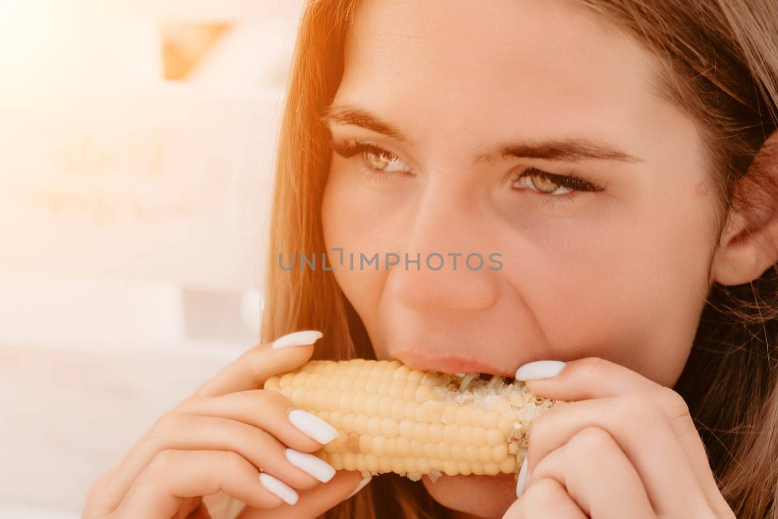 Healthy vegetarian hipster woman in summer outfit eat grilled corn and look to camera. Sexy lady on sea beach sunset or ocean sunrise. Travel, explore, active yoga and meditation lifestyle concept.