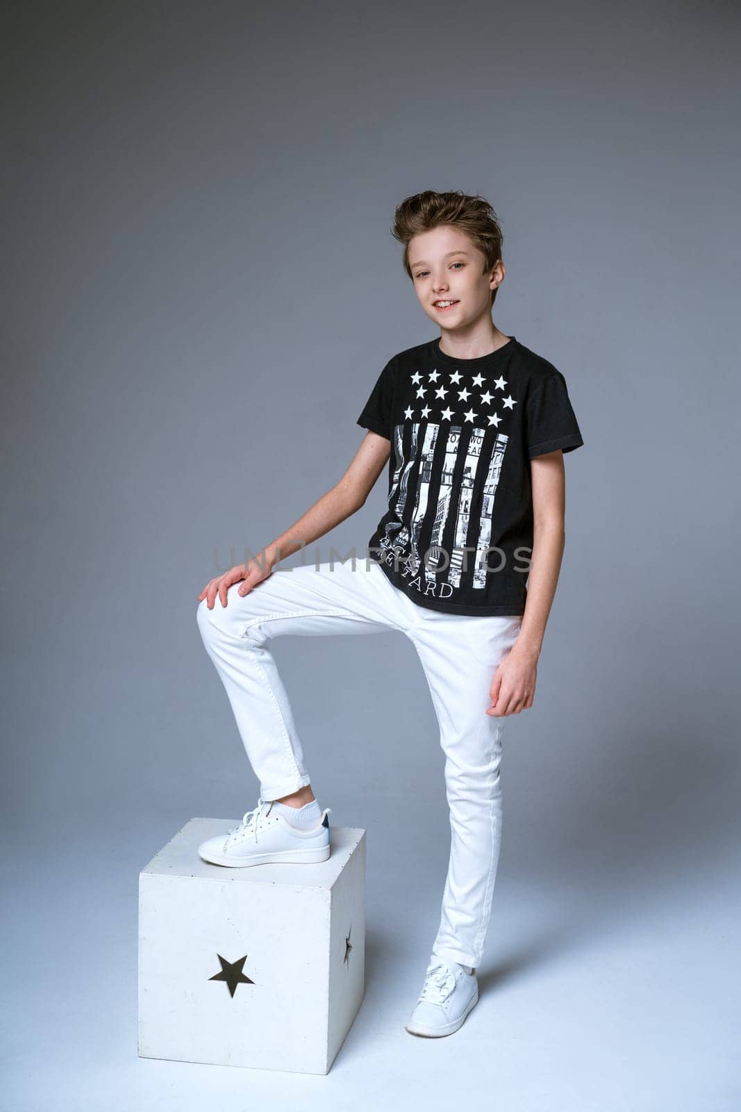 Boy posing on gray background in black t-shirt by EkaterinaPereslavtseva