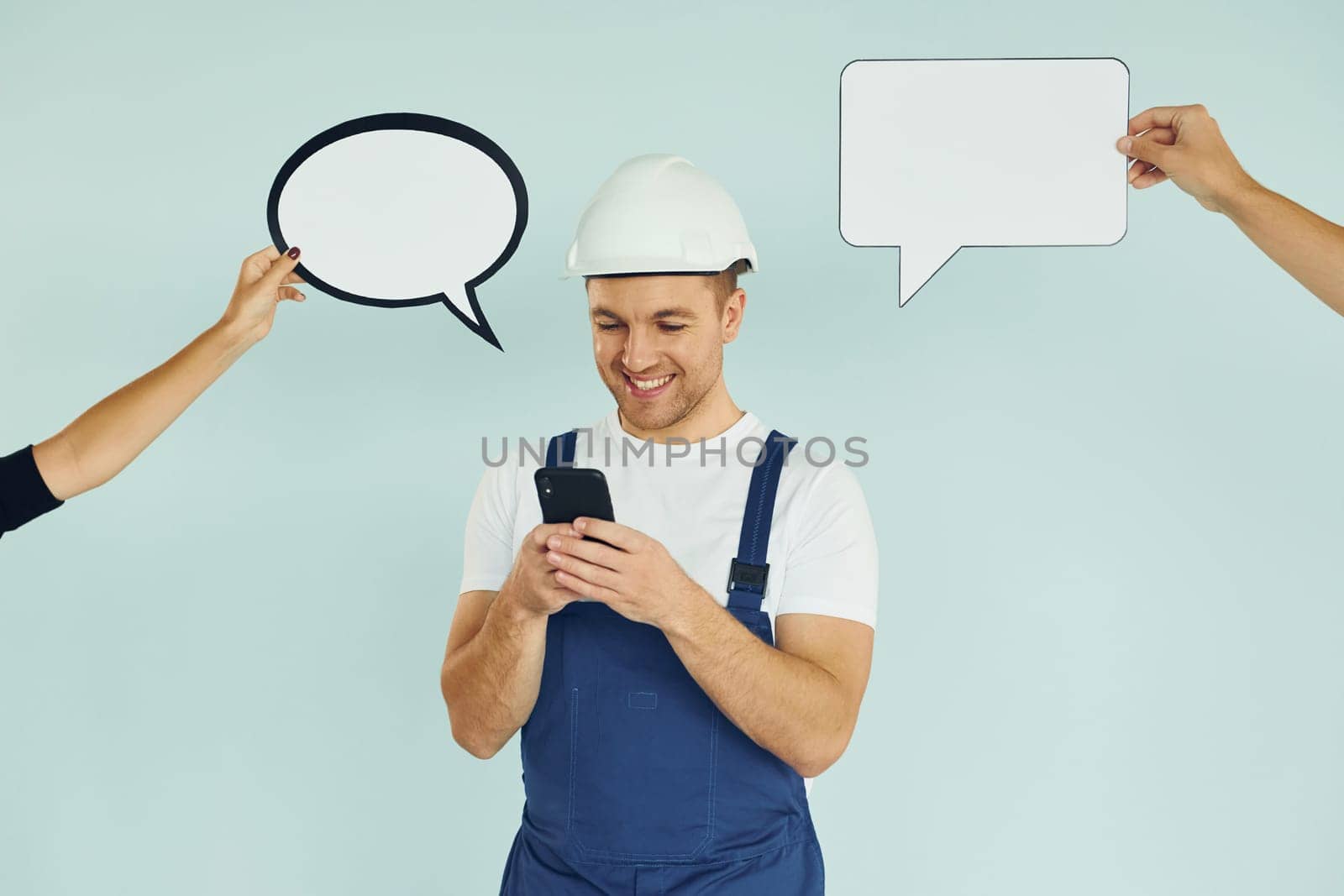 White hard hat and blue uniform. Man standing in the studio with empty signs for the text.