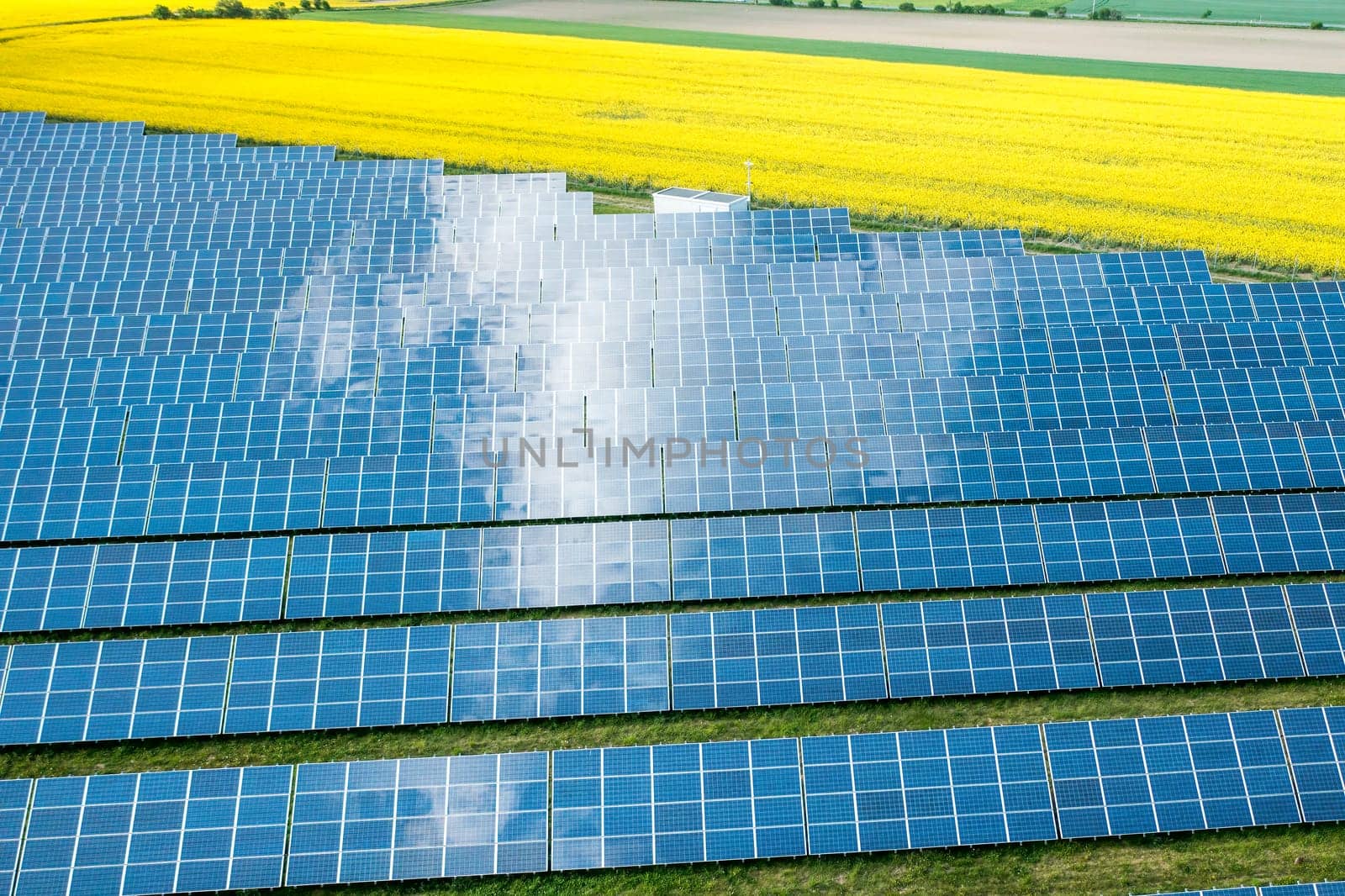 Solar panel for generation of direct current electricity in the yellow field. Photovoltaic and alternative resource of power, aerial view