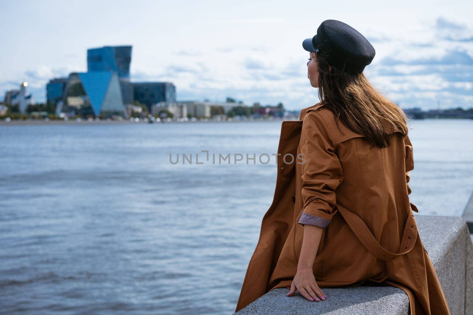 Sad lonely woman sitting on the embankment of the river by EkaterinaPereslavtseva