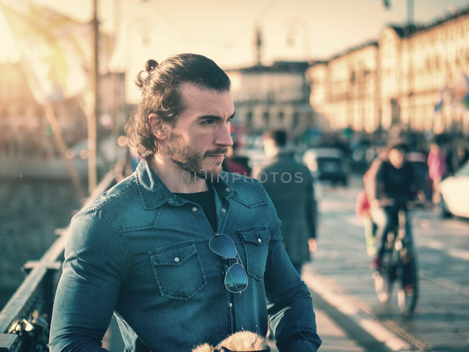 One handsome young man in urban setting in European city, Turin in Italy, standing and looking away