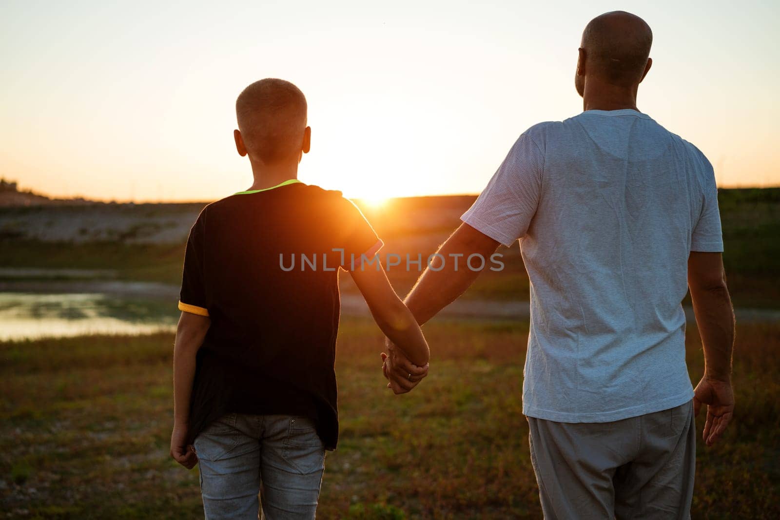 Son and dad stand against the backdrop of a colorful by EkaterinaPereslavtseva