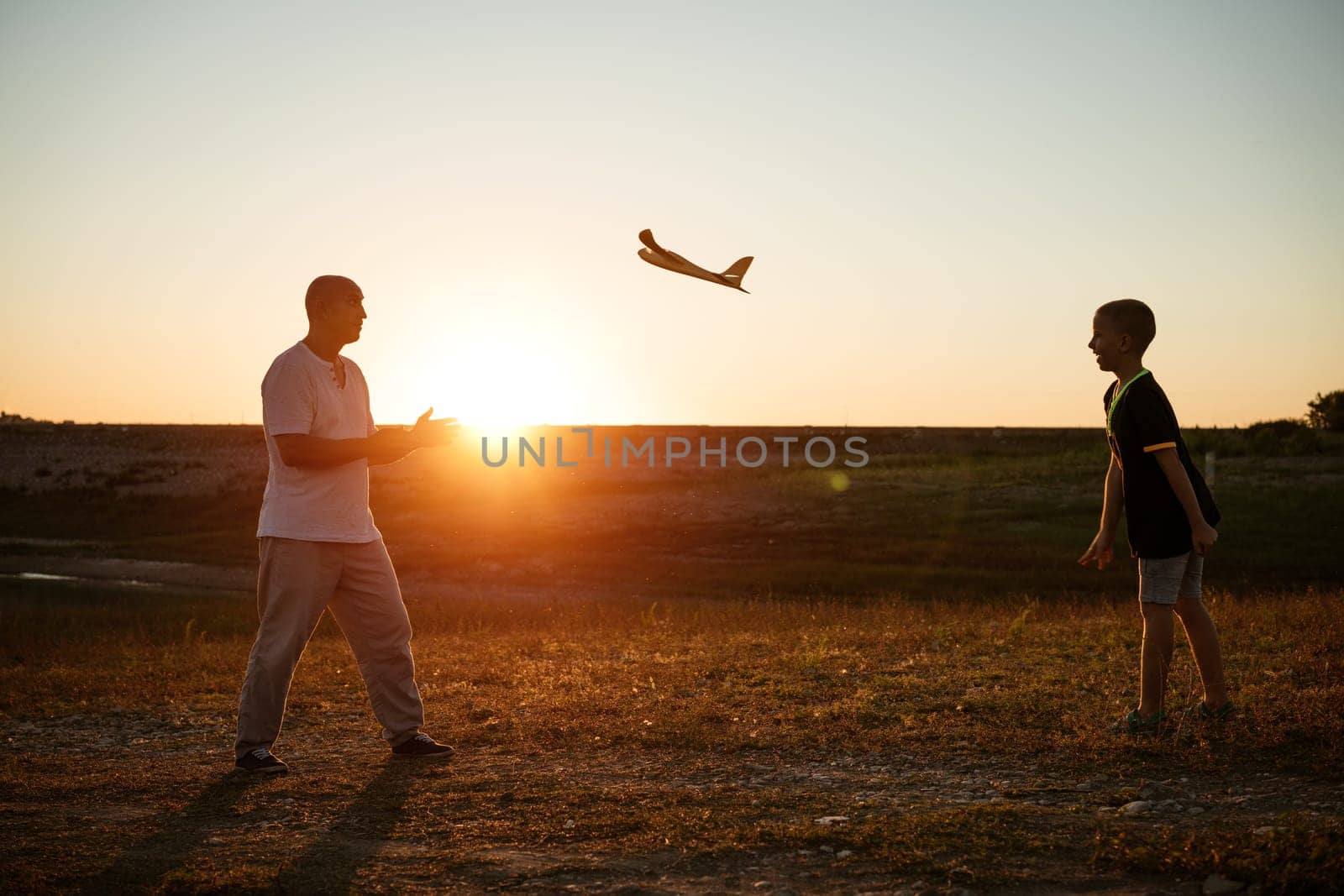 Soft focus of father and son playing toy airplane by EkaterinaPereslavtseva