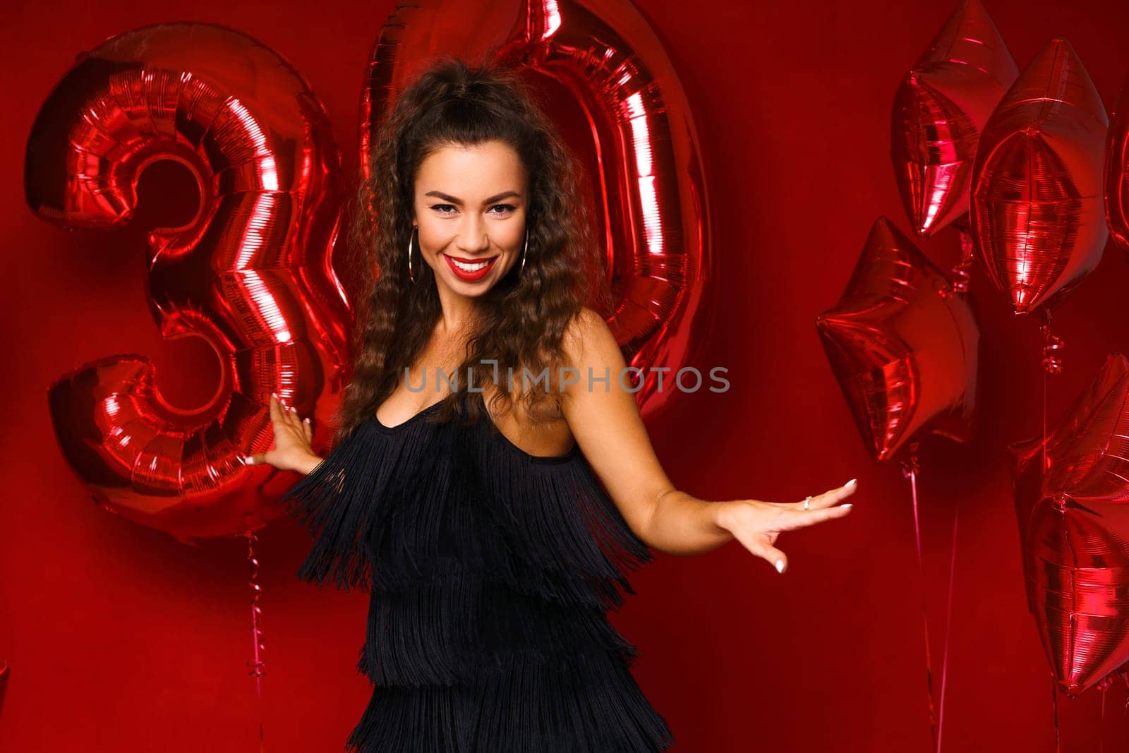 Portrait of happy 30 year old woman on red background by EkaterinaPereslavtseva